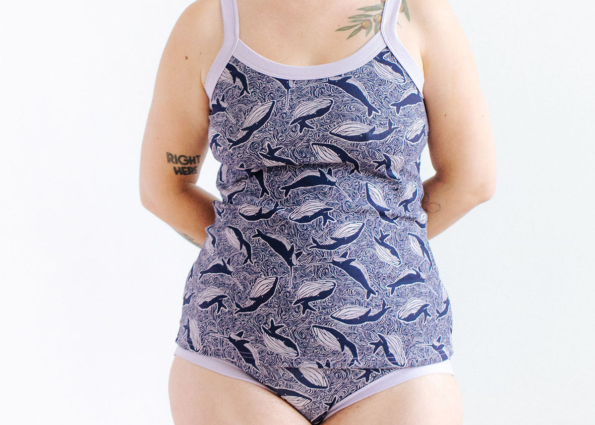 Model wearing Thunderpants Cami in Whale, Whale, Whale print - blue whales on lavender.