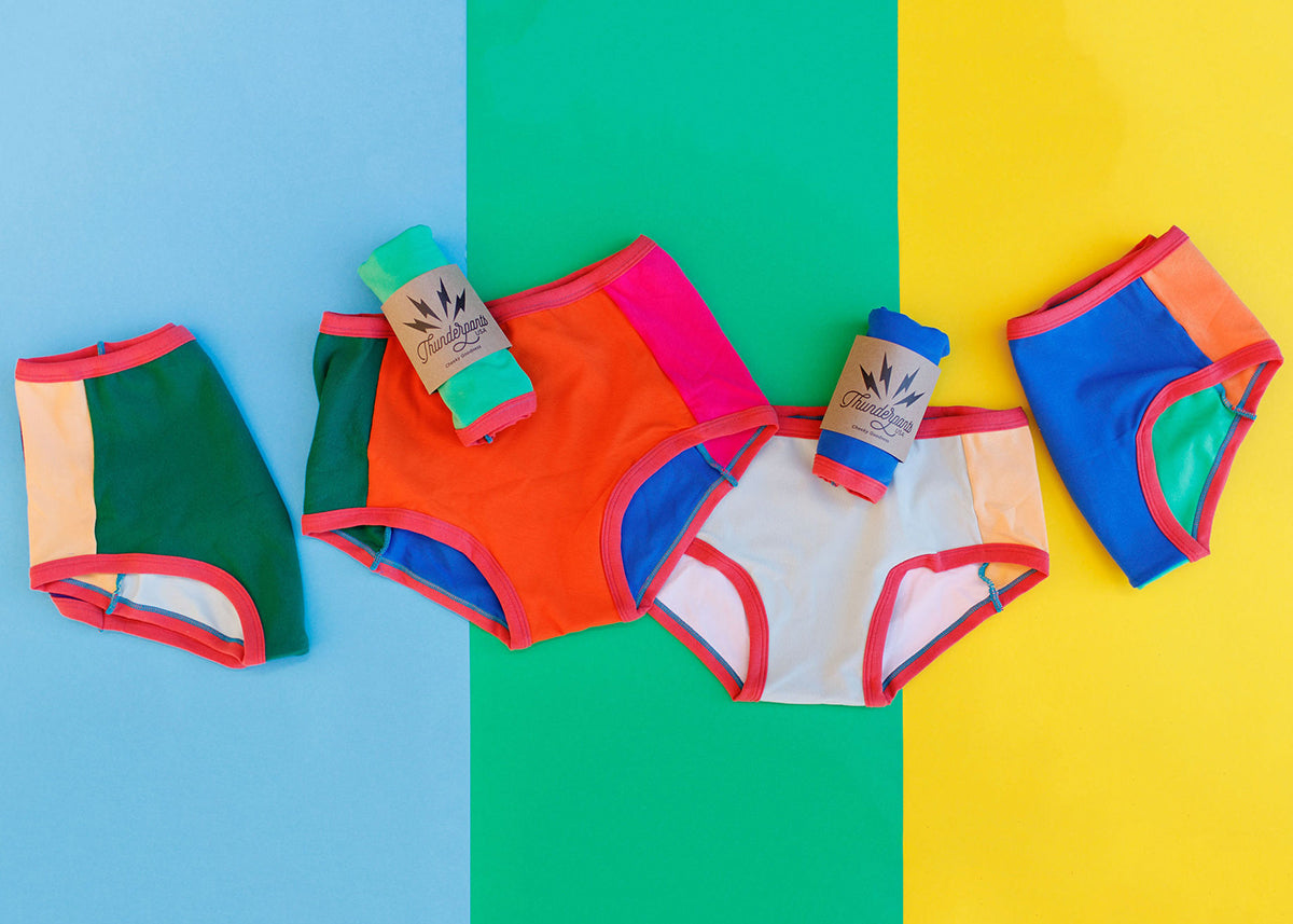 Flat lay of Thunderpants Original and Hipster style Panel Pants underwear in Color Block Scrap - multiple solid fabric colors.