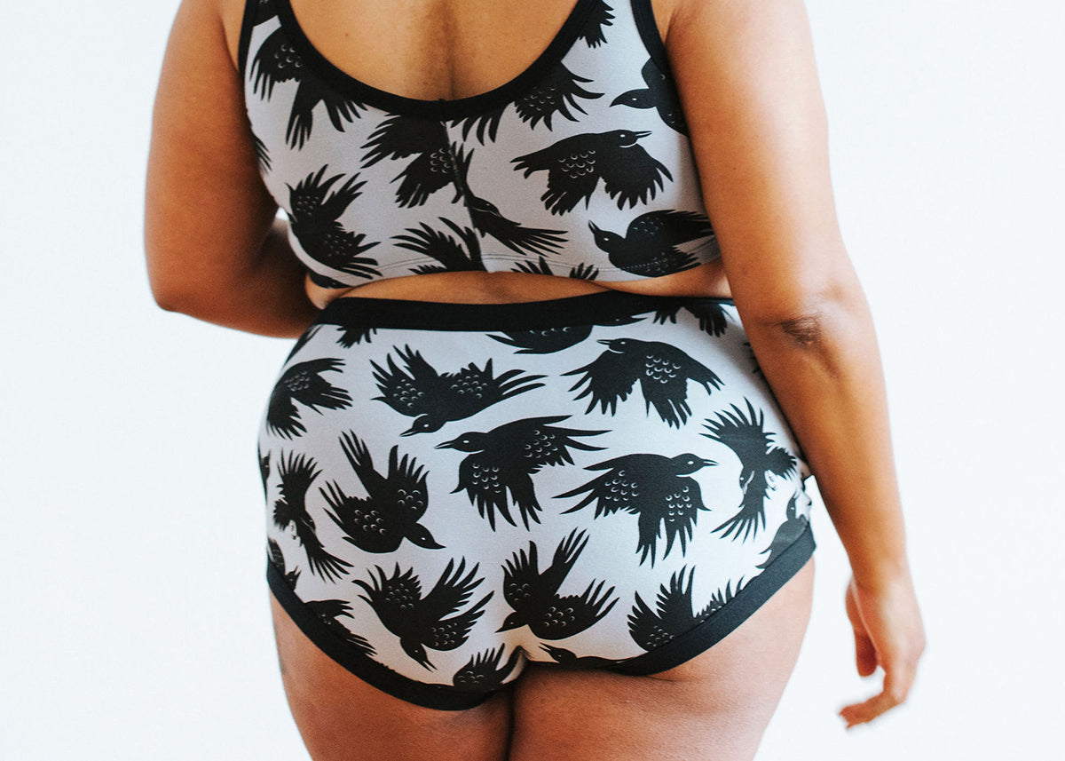 Close up of model wearing Thunderpants Original style underwear and Longline Bra in So it Crows - black birds on grey.