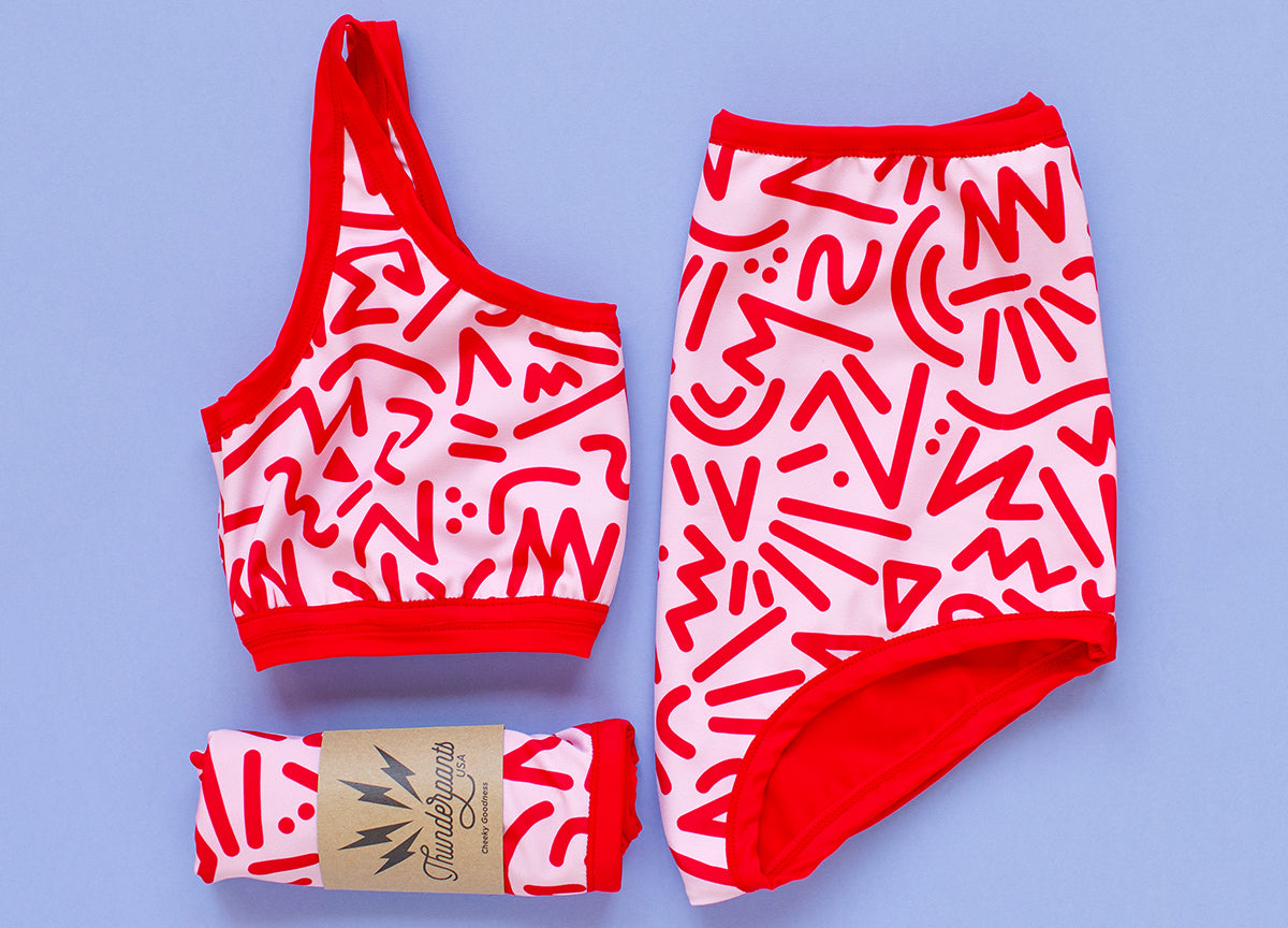 Flat lay of Thunderpants Swimwear Top and Sky Rise Bottoms in Energy Vibes print.