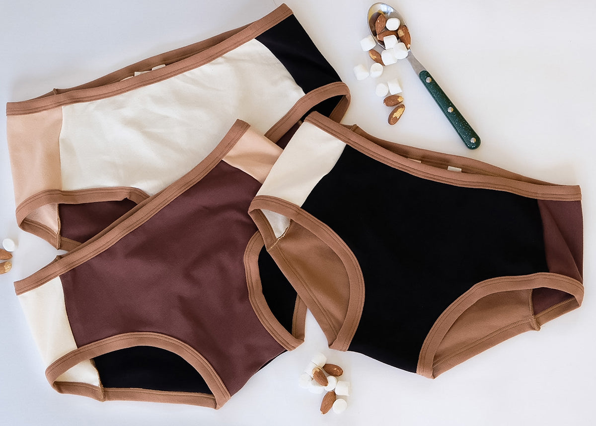 Multiple pairs of Thunderpants Panel Pants style underwear in various neutral colors.