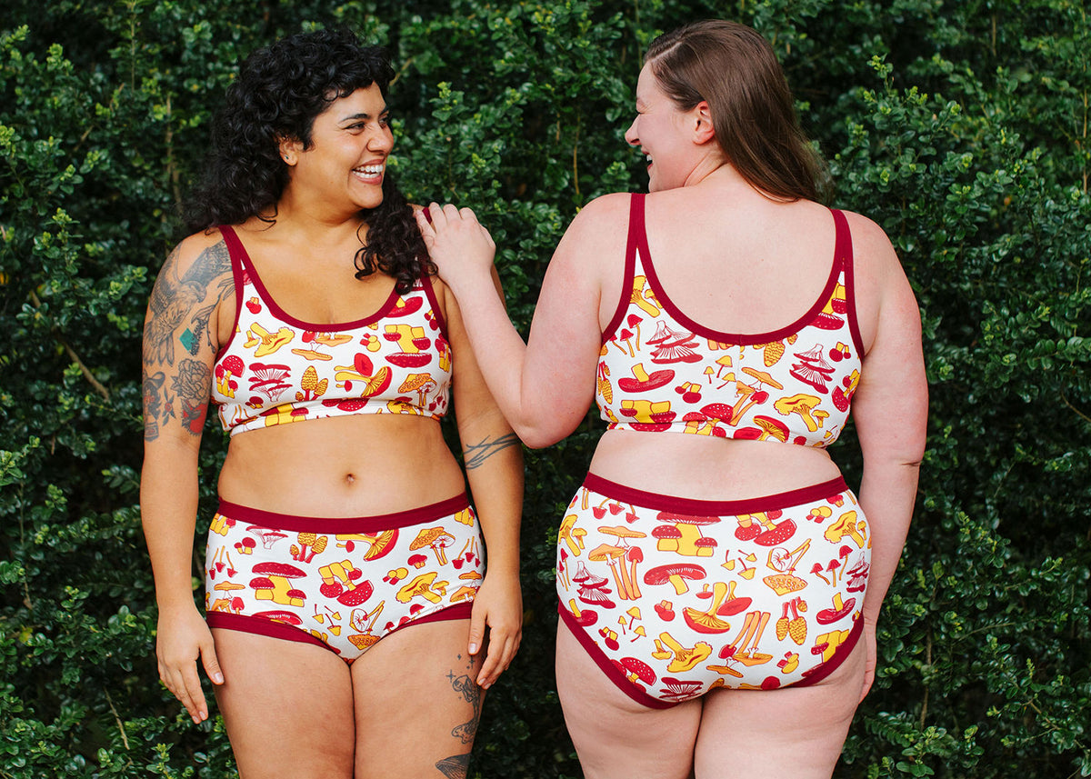 Two models wearing Thunderpants Bralette and underwear in Whadda Fungi print - red, yellow, and orange mushroom print.