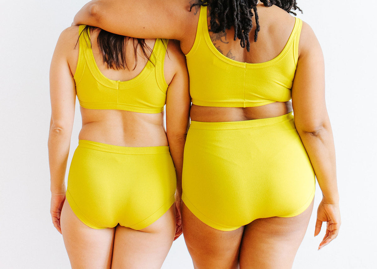 Two models bums wearing Thunderpants Original and Sky Rise style underwear with Bras in Star Fruit color - a chartreuse yellow.
