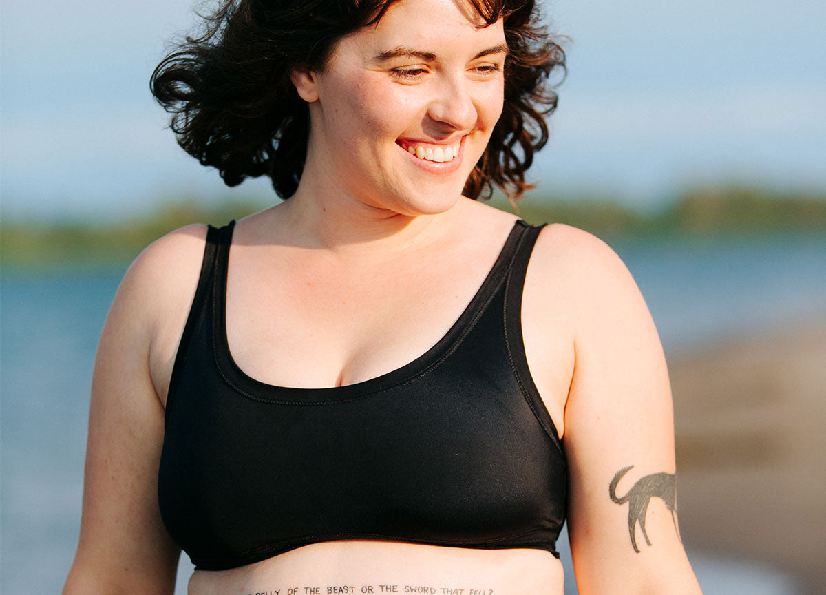 Model smiling wearing Swimwear Top in Plain Black.