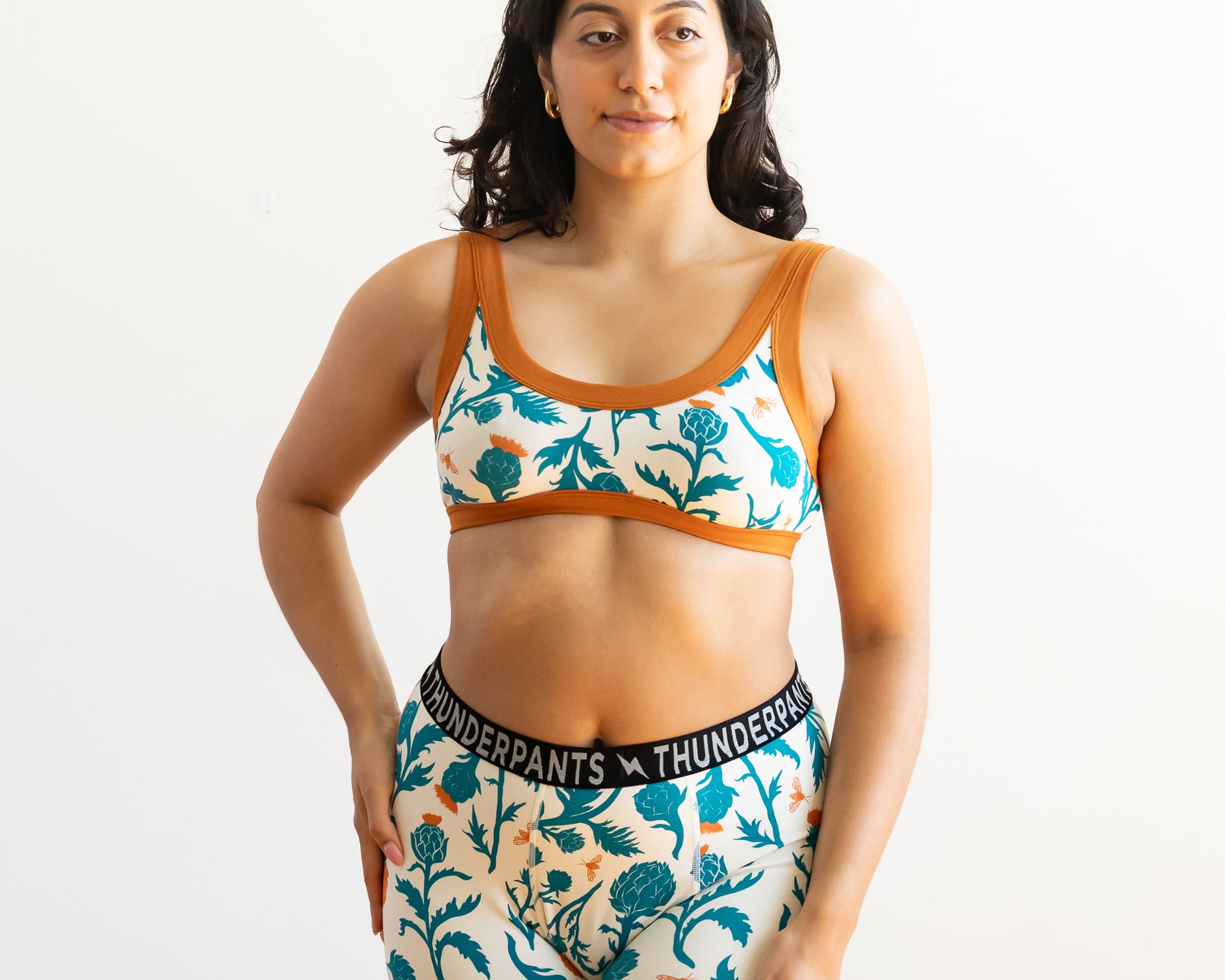 Model wearing Thunderpants Boxer Brief style underwear and Bralette in Robben's Artichokes print - teal and rust artichokes and bees.