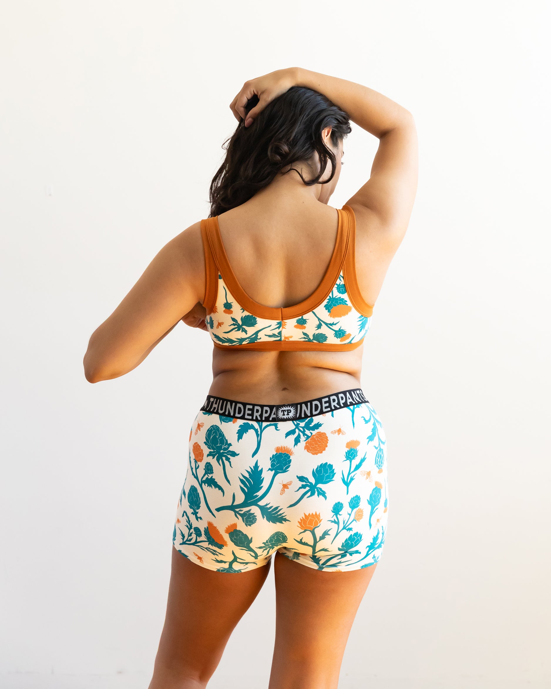 Model wearing Thunderpants Boxer Brief style underwear and Bralette in Robben's Artichokes print - teal and rust artichokes and bees.