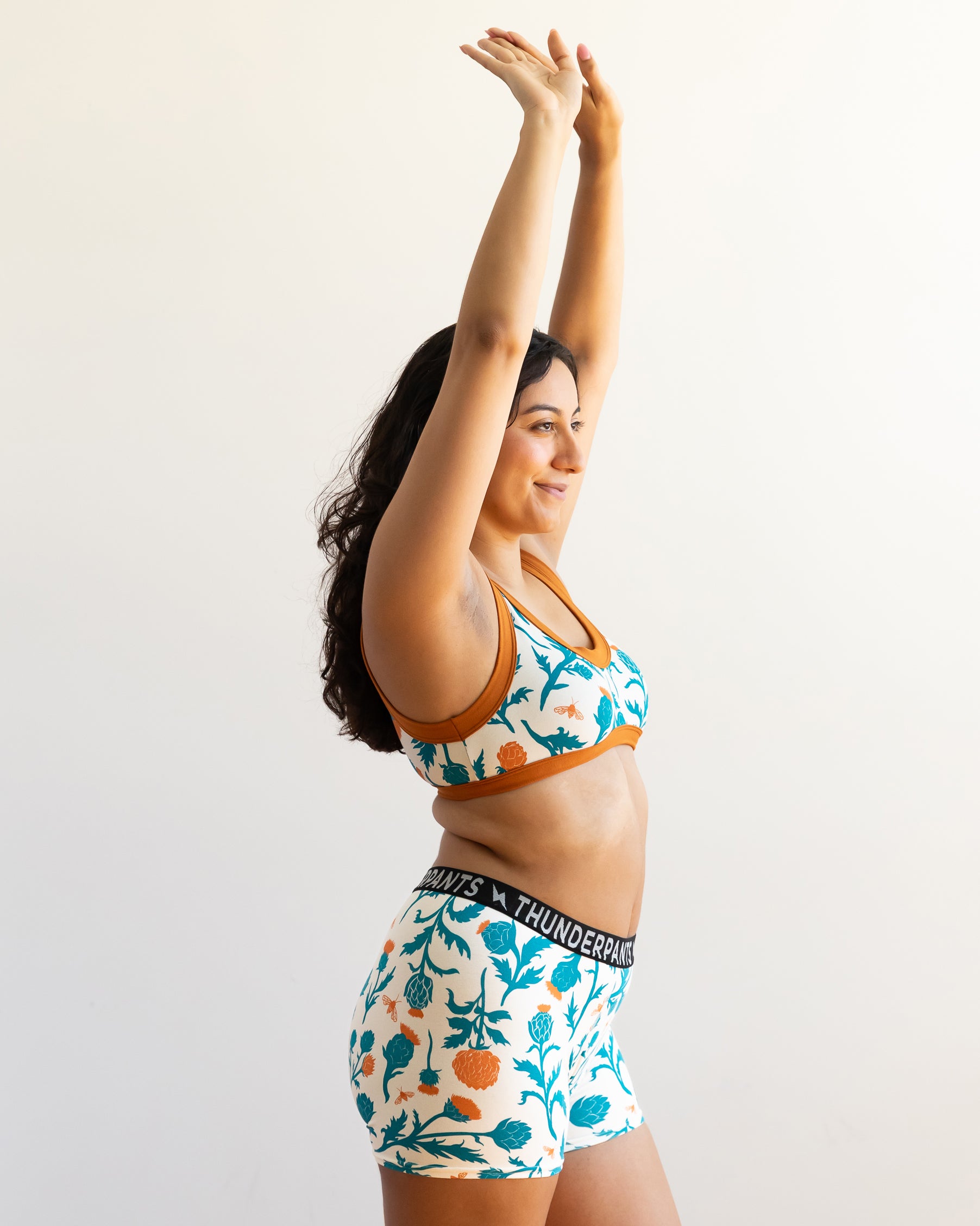 Model wearing Thunderpants Bralette and Boxer Brief style underwear in Robben's Artichokes print - teal and rust artichokes and bees.