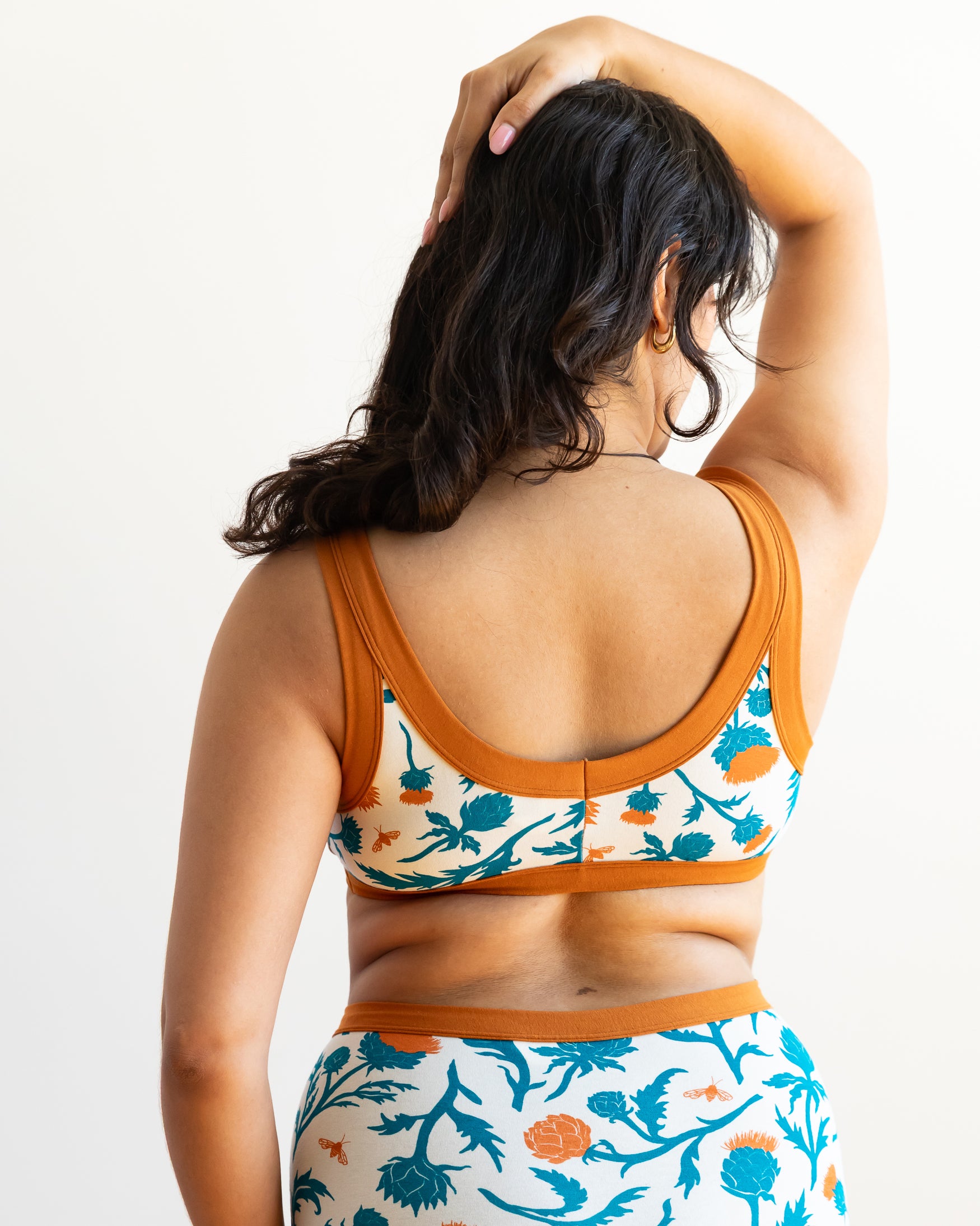 Model wearing Thunderpants Bralette in Robben's Artichokes print - teal and rust artichokes and bees.