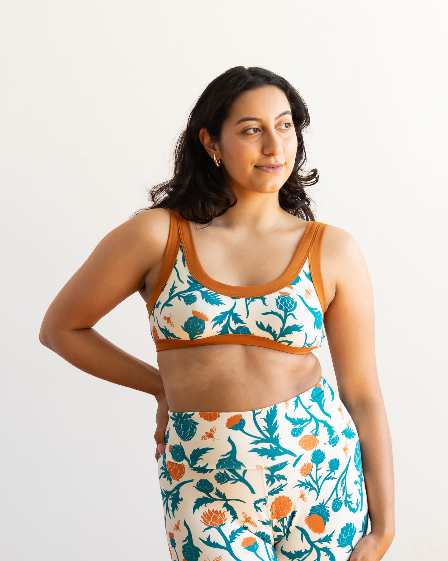 Model wearing Thunderpants Bralette and Bike Shorts in Robben's Artichokes print - teal and rust artichokes and bees.