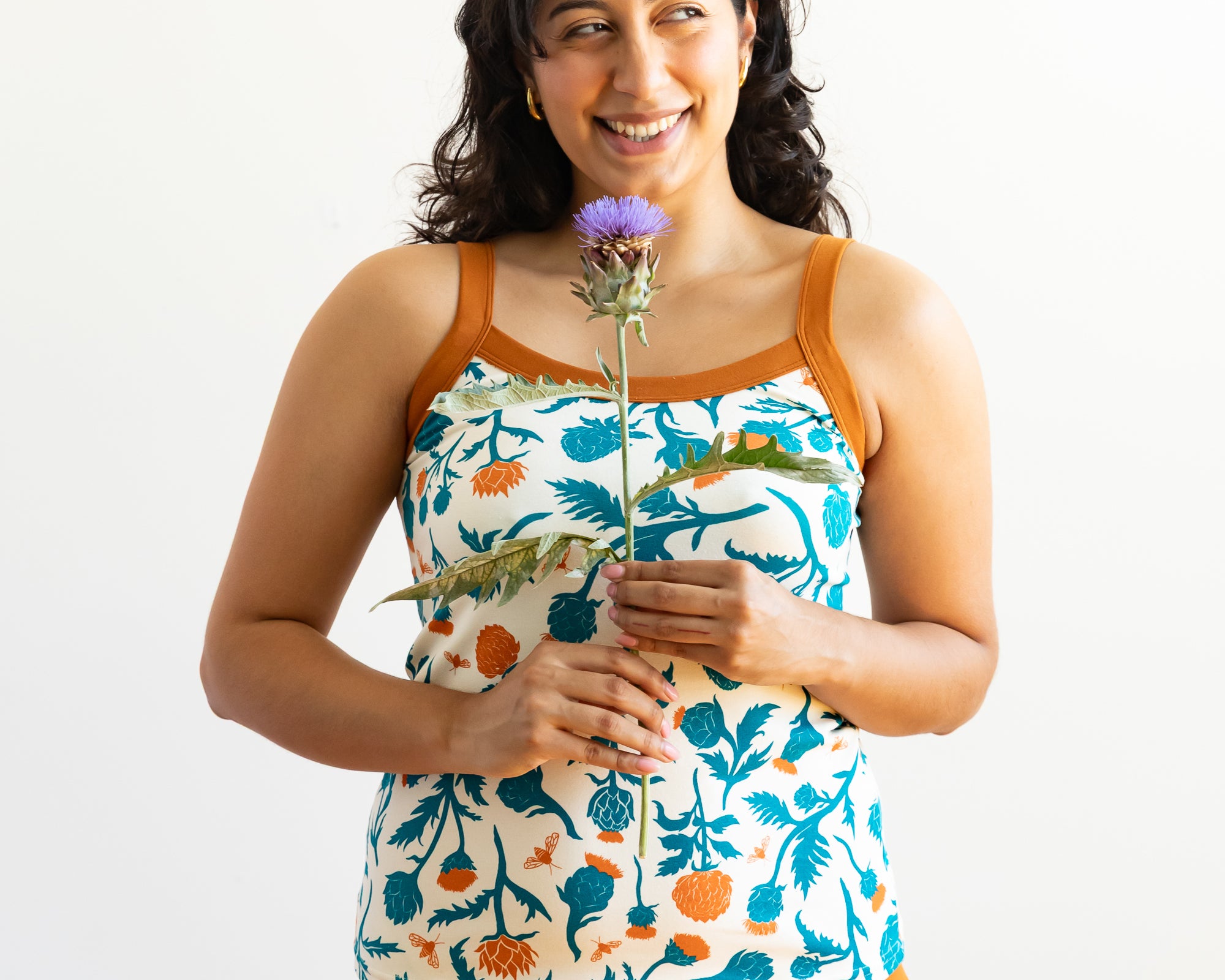 Model wearing Thunderpants Cami and Hipster style underwear in Robben's Artichokes print - teal and rust artichokes and bees.