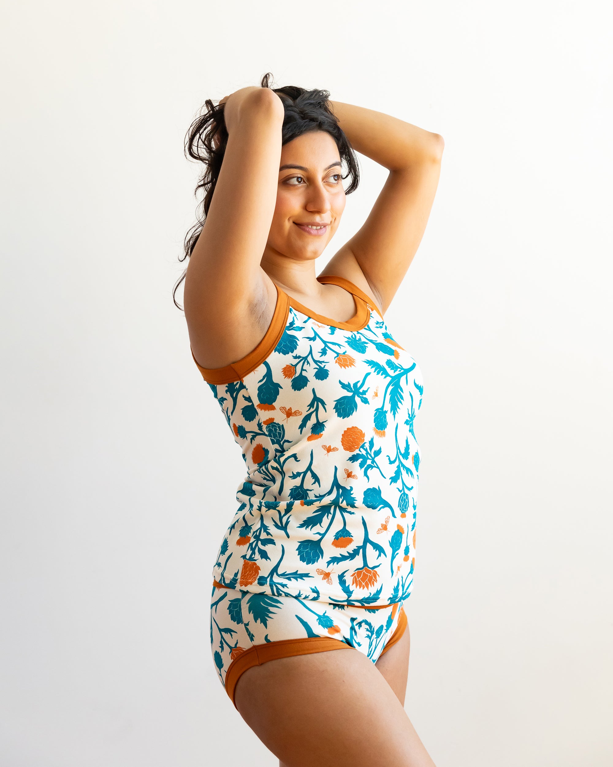 Model wearing Thunderpants Cami and Hipster style underwear in Robben's Artichokes print - teal and rust artichokes and bees.