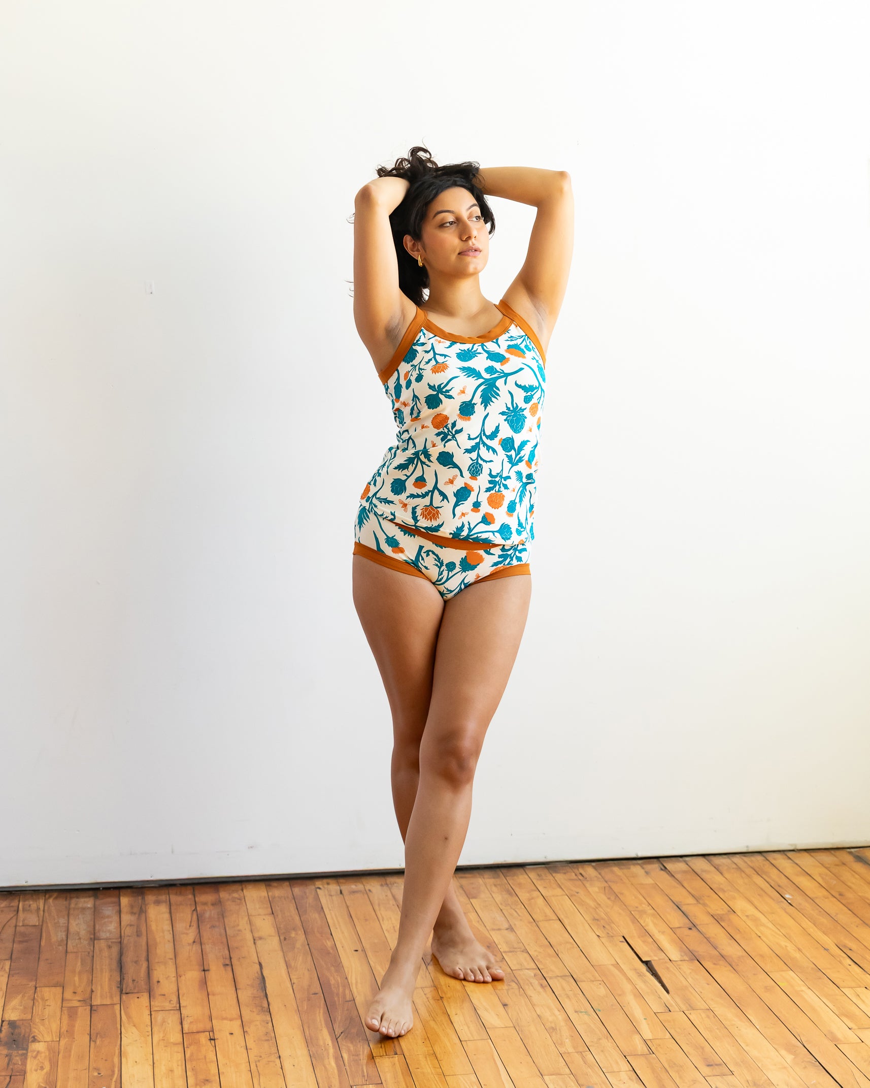 Model wearing Thunderpants Cami and Hipster style underwear in Robben's Artichokes print - teal and rust artichokes and bees.