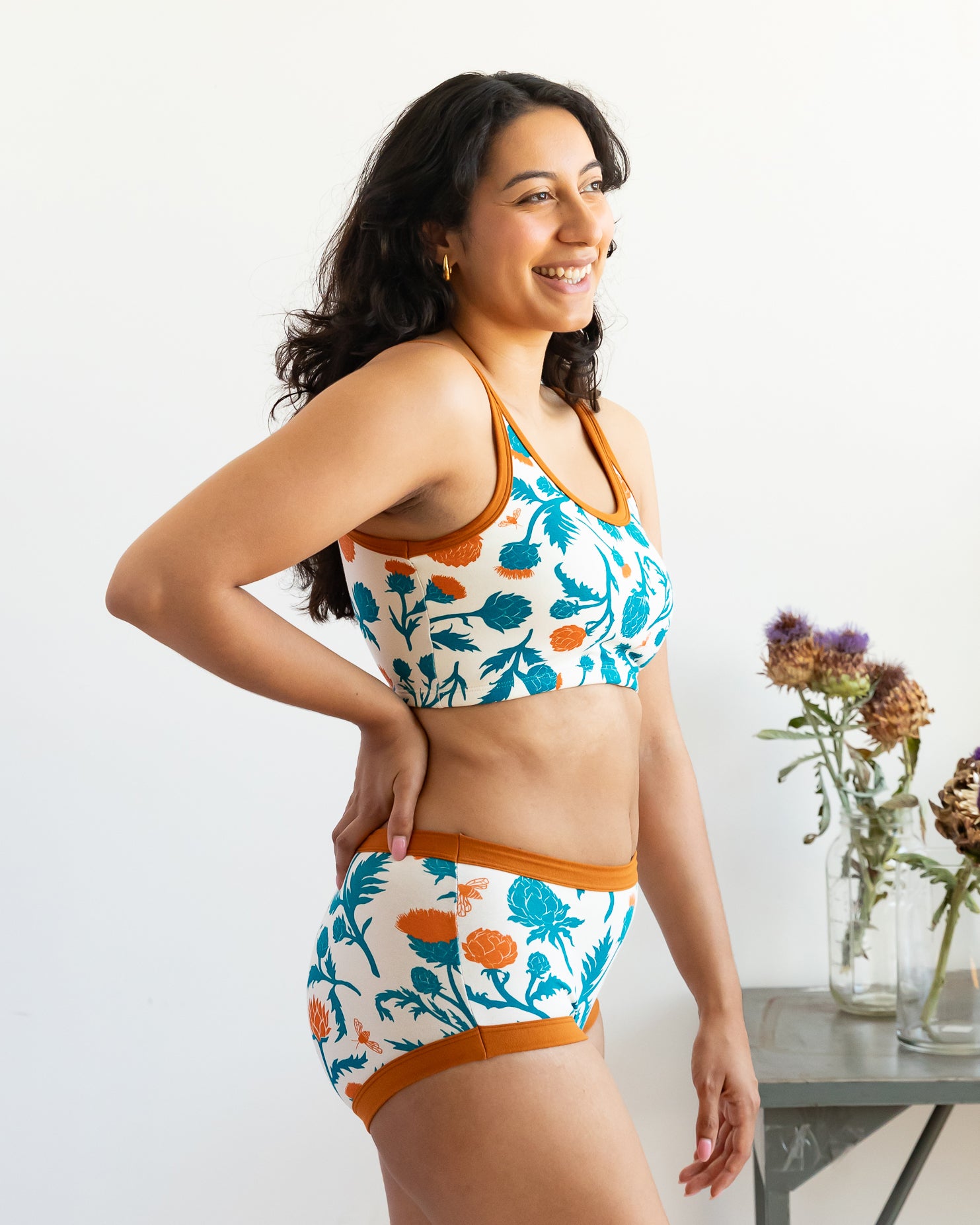 Model wearing Thunderpants Longline Bra and Original style underwear in Robben's Artichokes print - teal and rust artichokes and bees.