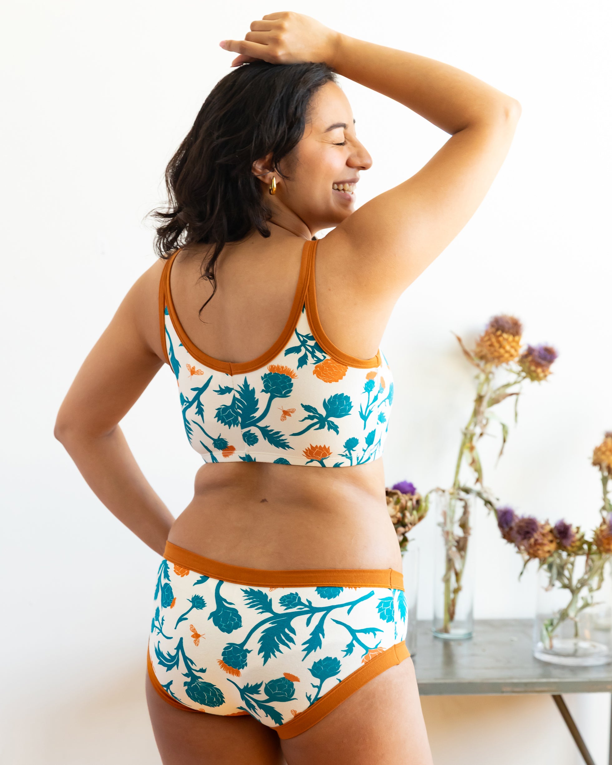 Model wearing Thunderpants Longline Bra and Hipster style underwear in Robben's Artichokes print - teal and rust artichokes and bees.