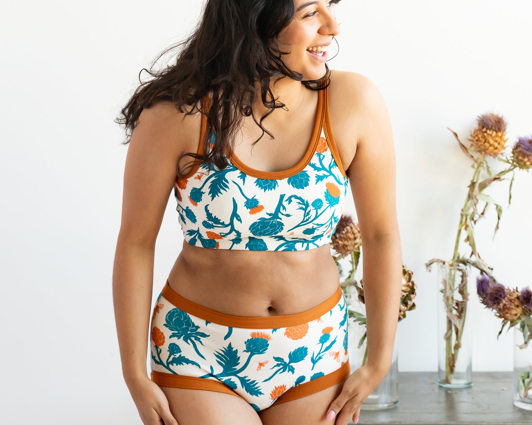 Model wearing Thunderpants Original style underwear and Longline bra in Robben's Artichokes print - teal and rust artichokes and bees.
