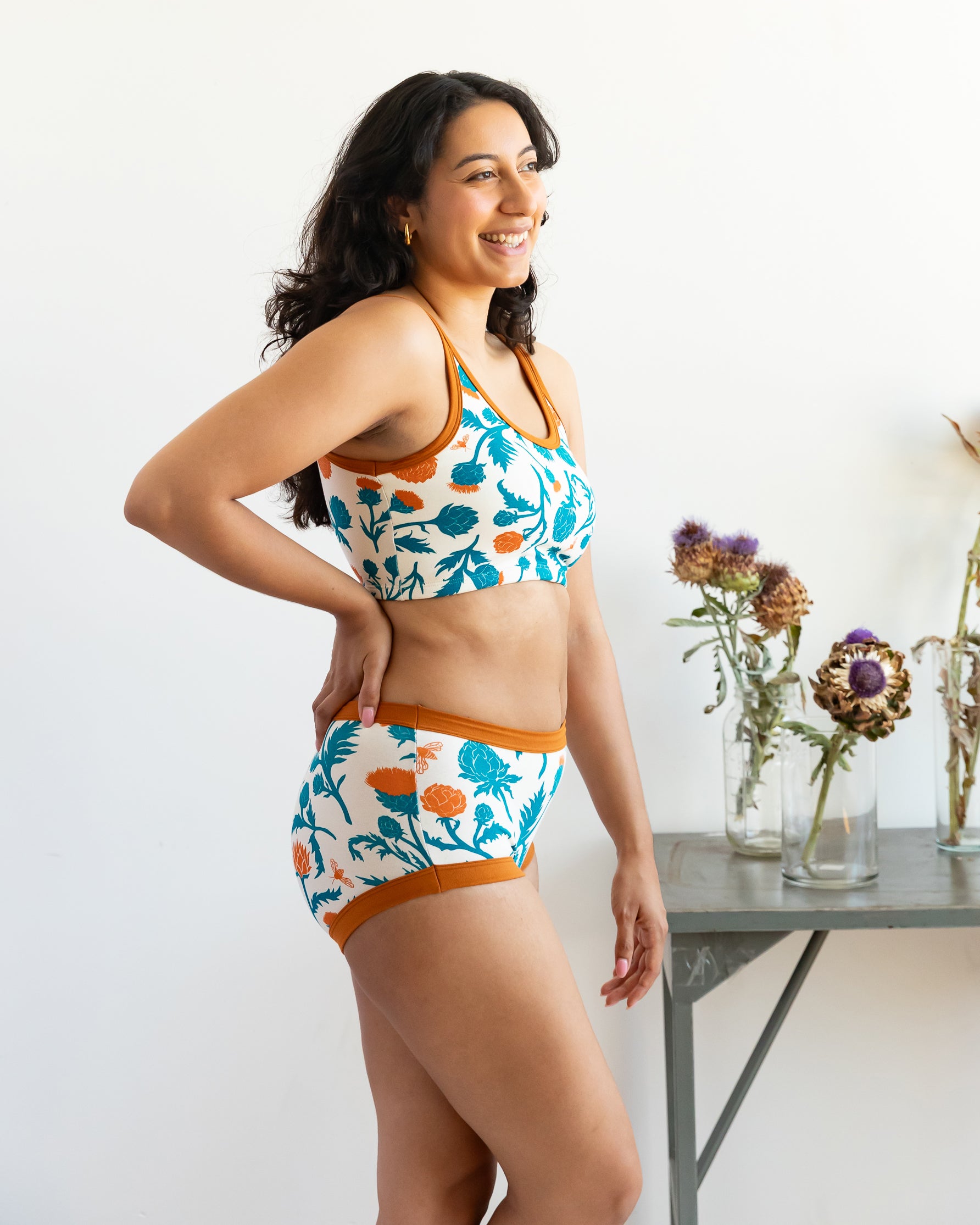 Model wearing Thunderpants Original style underwear and Longline bra in Robben's Artichokes print - teal and rust artichokes and bees.