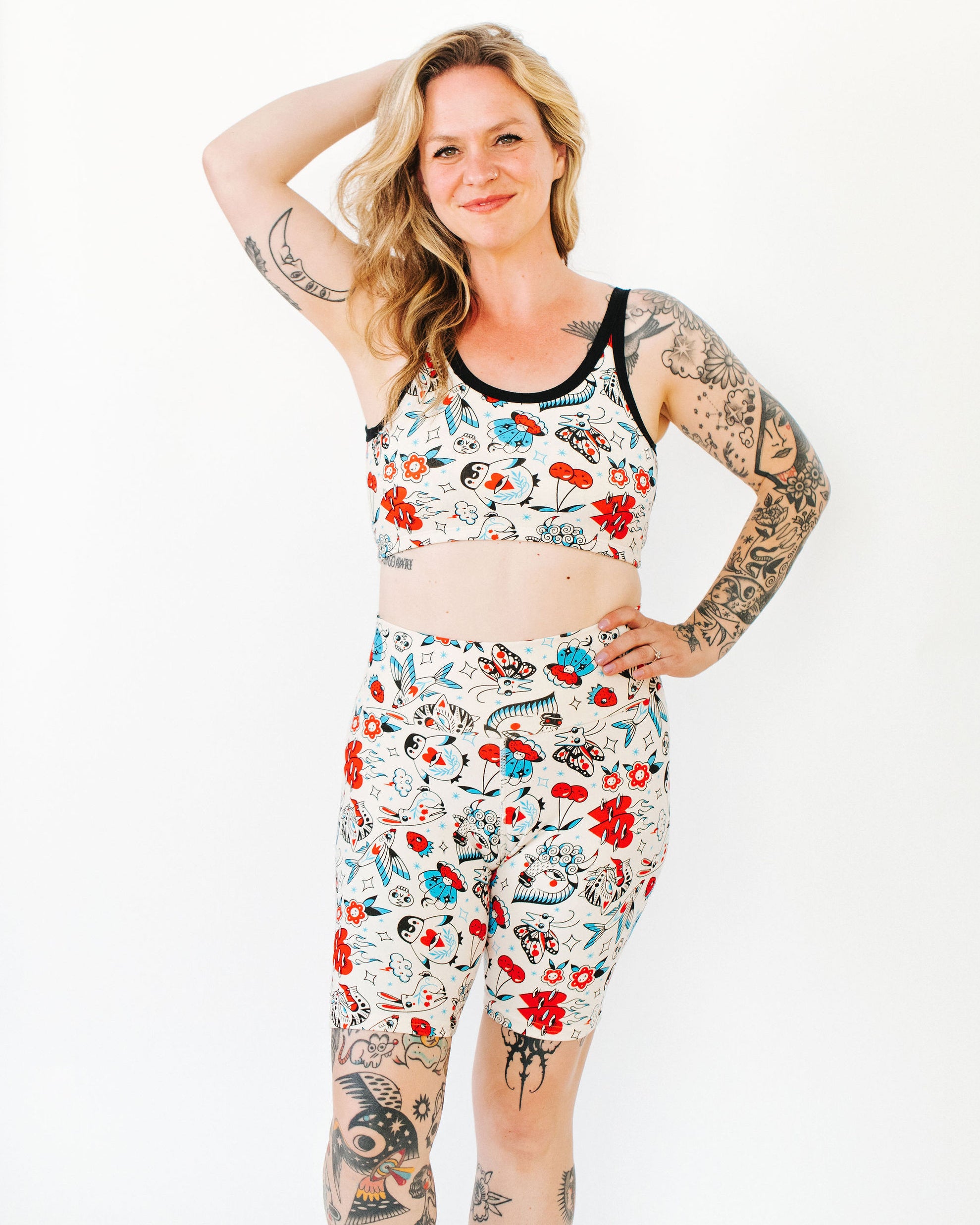 Model wearing Thunderpants Bike Shorts and Longline Bra in Inked Up - a tattoo pattern with black, red, and blue. 