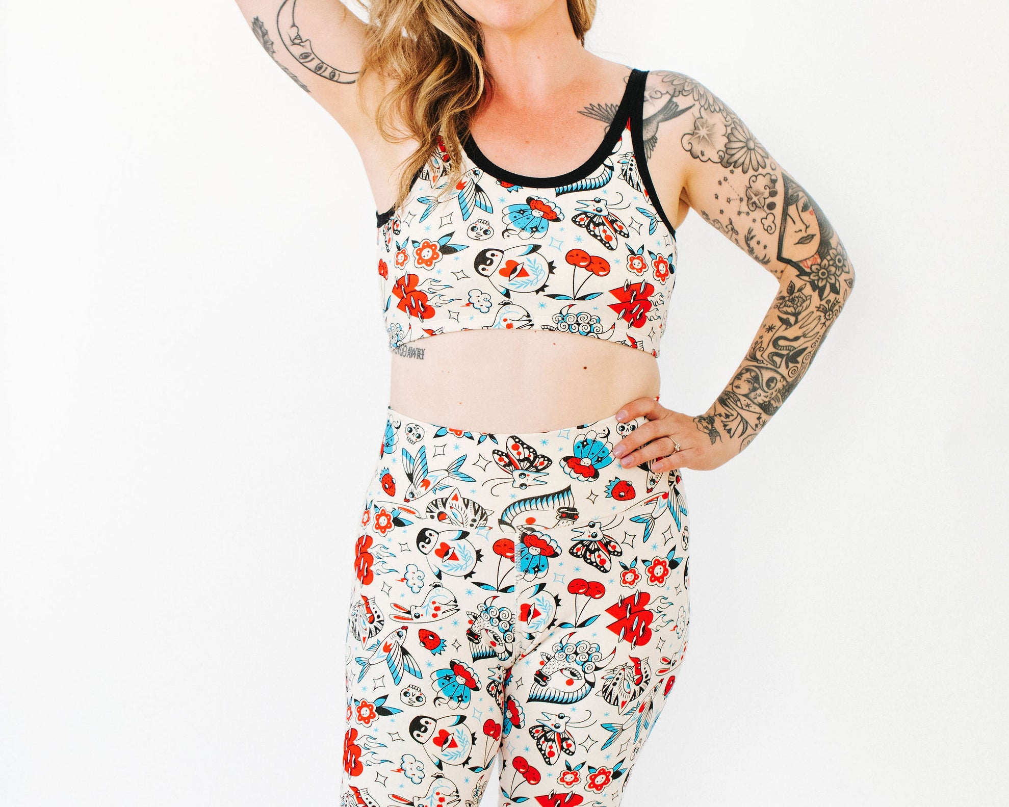 Model wearing Thunderpants Bike Shorts and Longline Bra in Inked Up - a tattoo pattern with black, red, and blue. 