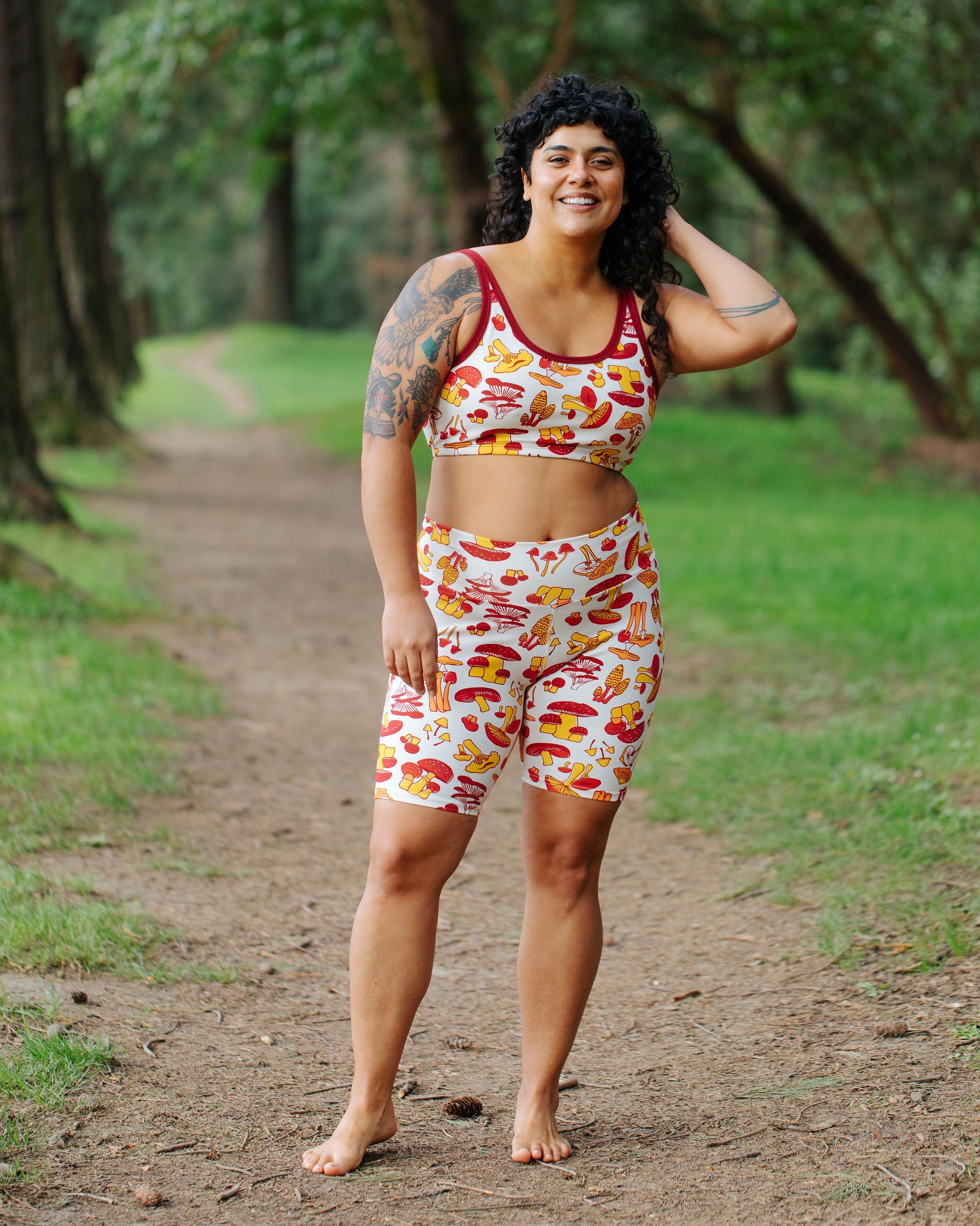 Model wearing Thunderpants Bike Shorts and Longline Bra in Whadda Fungi - red, yellow, and orange mushroom print.