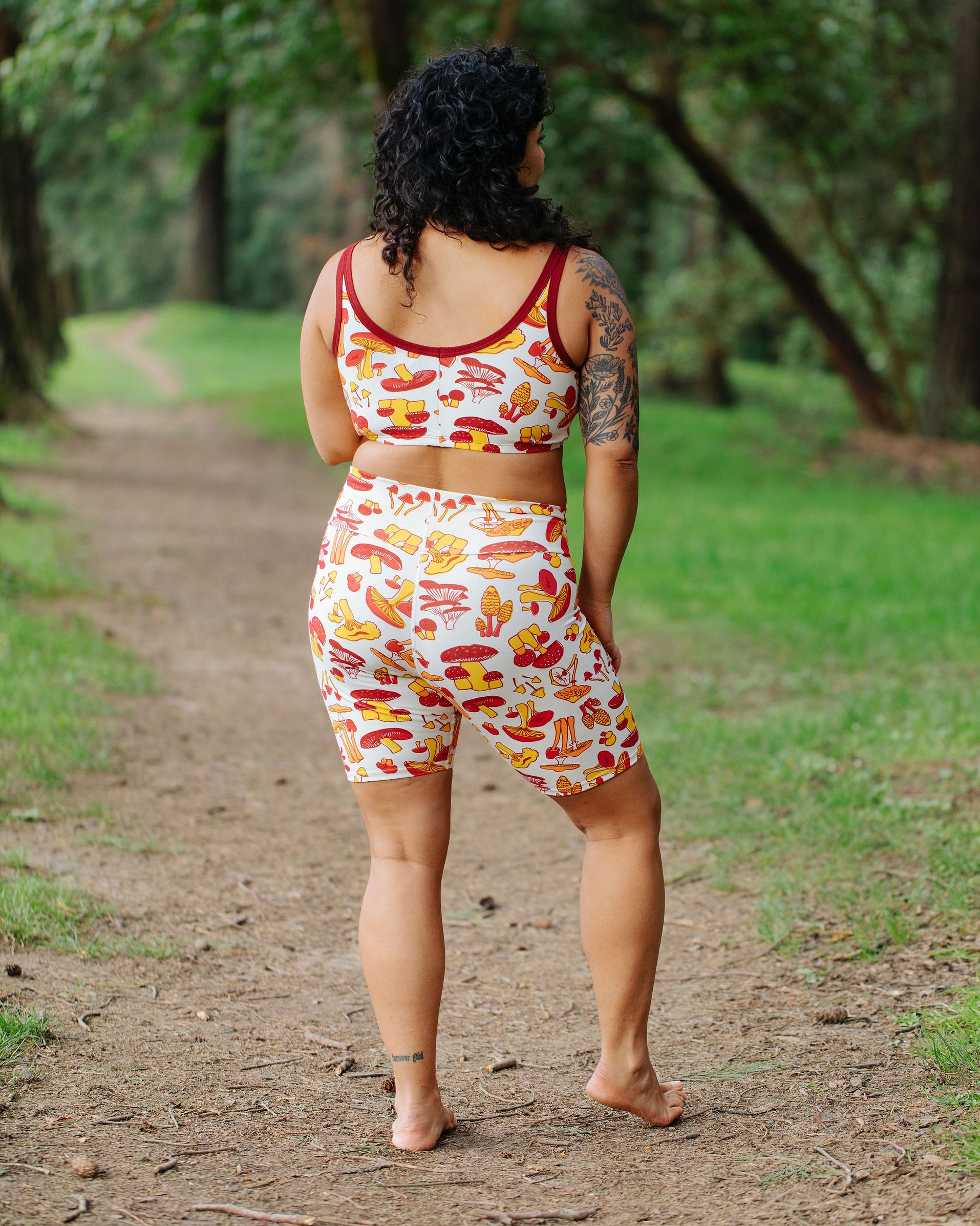 Model wearing Thunderpants Bike Shorts and Longline Bra in Whadda Fungi - red, yellow, and orange mushroom print.