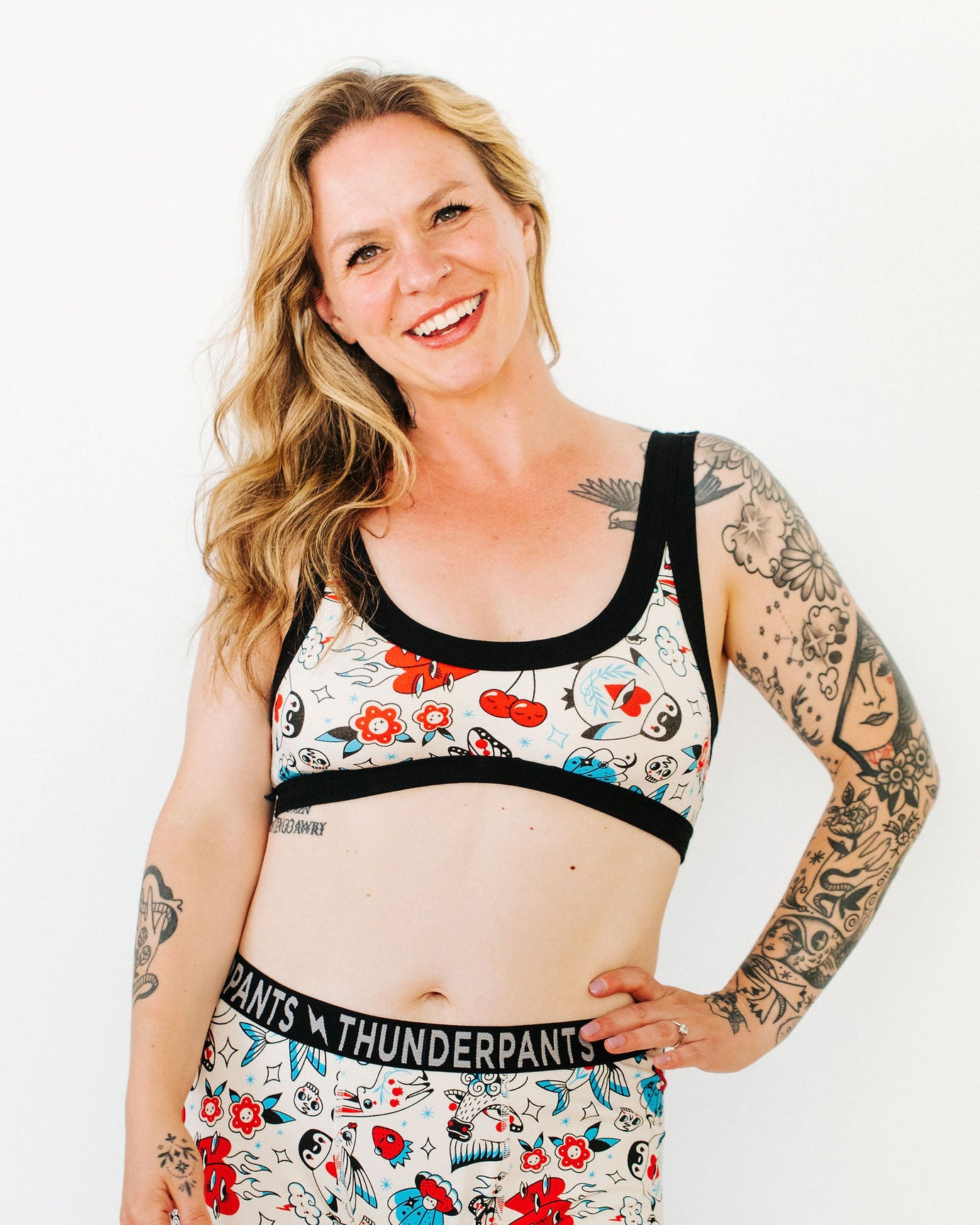 Model wearing Thunderpants Bralette and Boxer Brief style underwear in Inked Up - a tattoo pattern with black, red, and blue. 