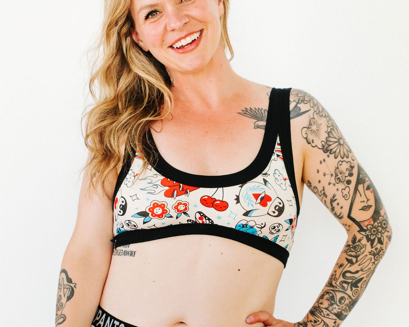 Model wearing Thunderpants Bralette and Boxer Brief style underwear in Inked Up - a tattoo pattern with black, red, and blue. 