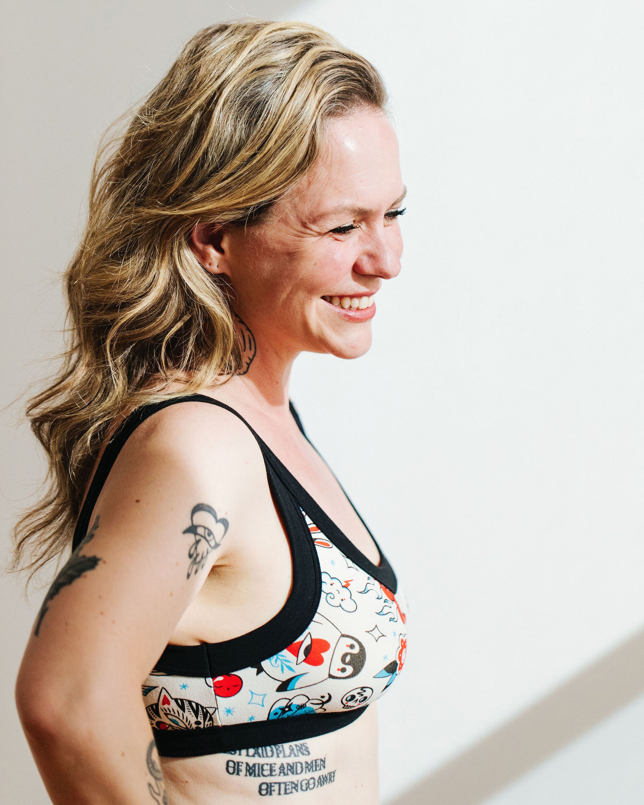 Model wearing Thunderpants Bralette in Inked Up - a tattoo pattern with black, red, and blue. 