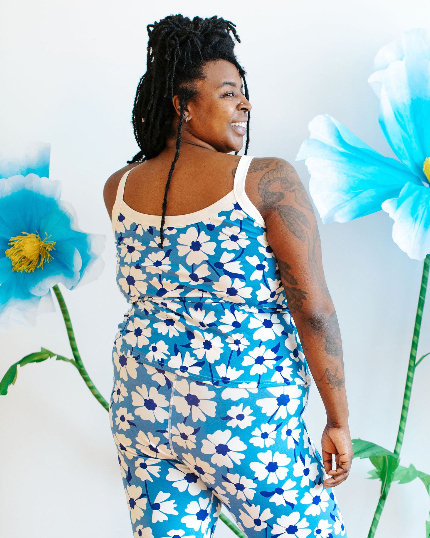 Model wearing Thunderpants Camisole  and Leggings in Moody Blooms - white and blue flowers with blue background.