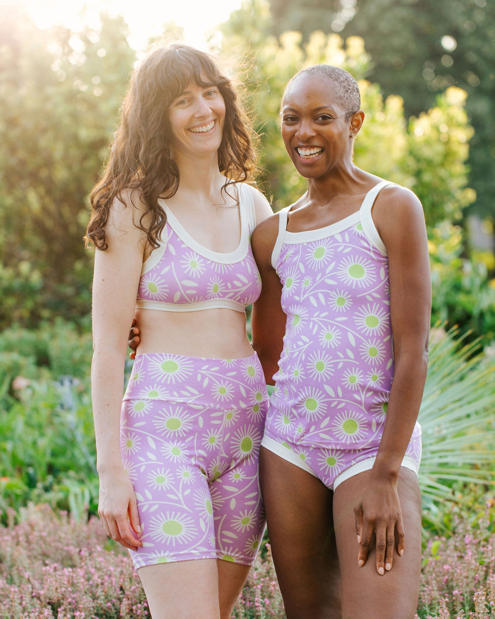 Models wearing Thunderpants Cami and Hipster style underwear, Bike Shorts and Bralette in Delia's Daisy - white, green, and purple daisies print.