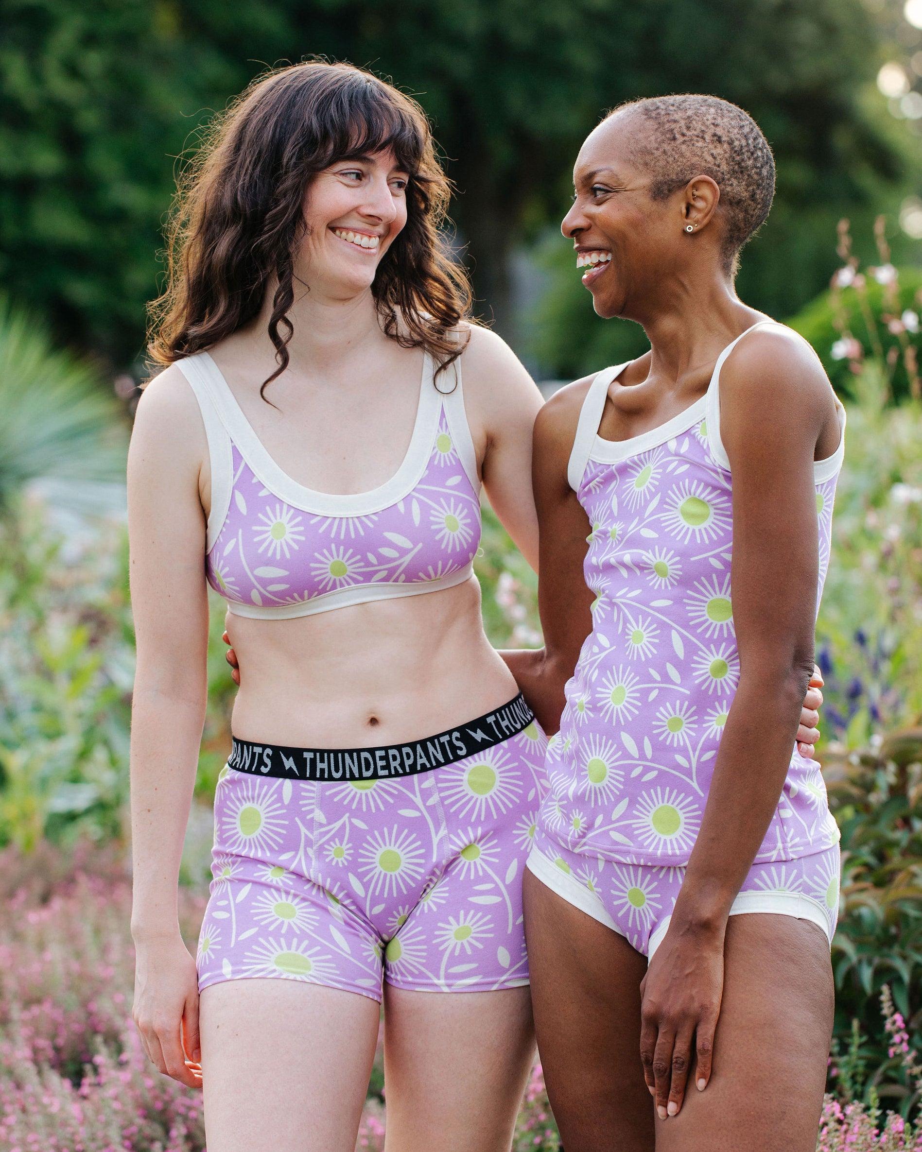 Models wearing Thunderpants Boxer Brief style underwear and other items in Delia's Daisy - white, green, and purple daisies print.