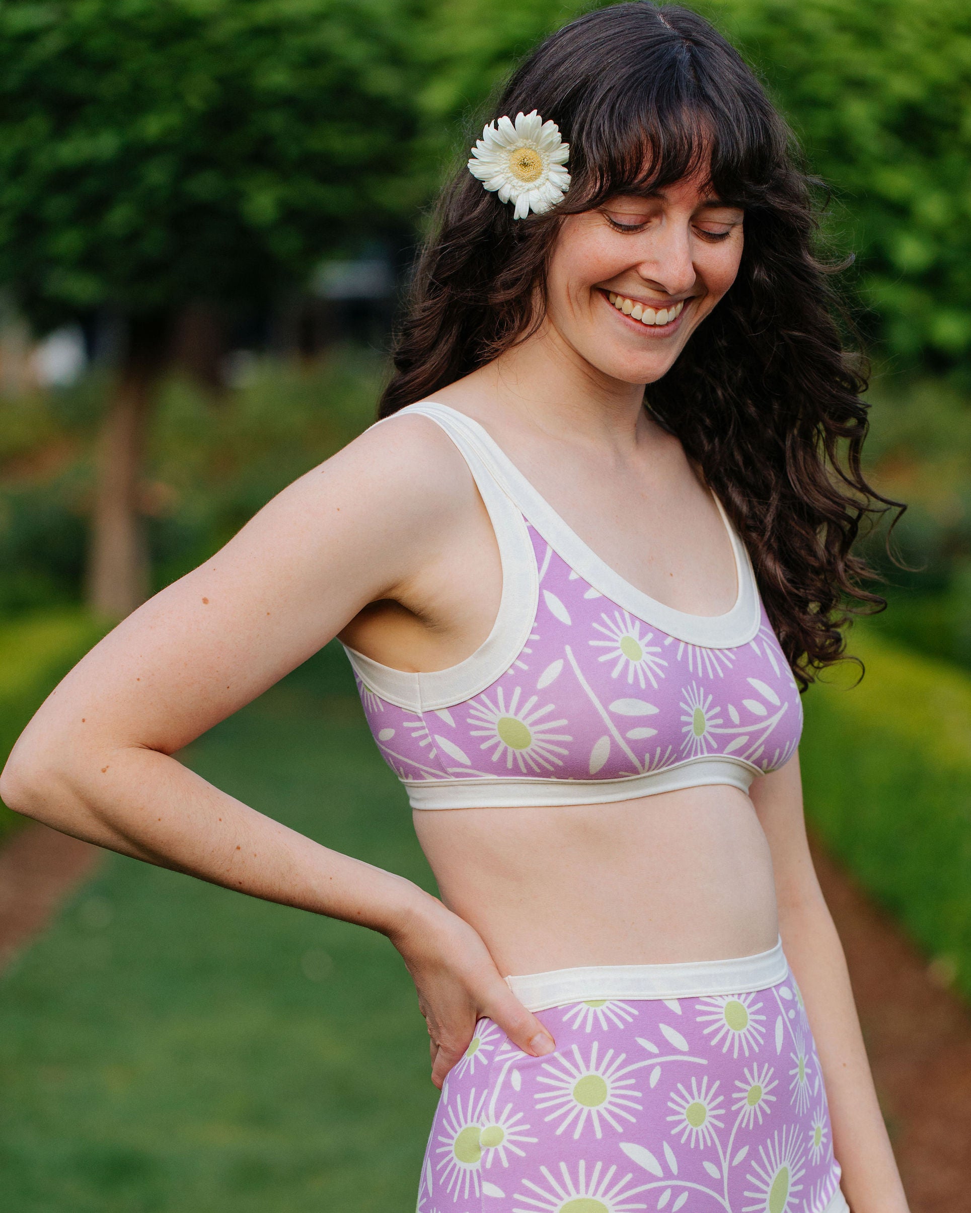 Model wearing Thunderpants Bralette in Delia's Daisy - white, green, and purple daisies print.