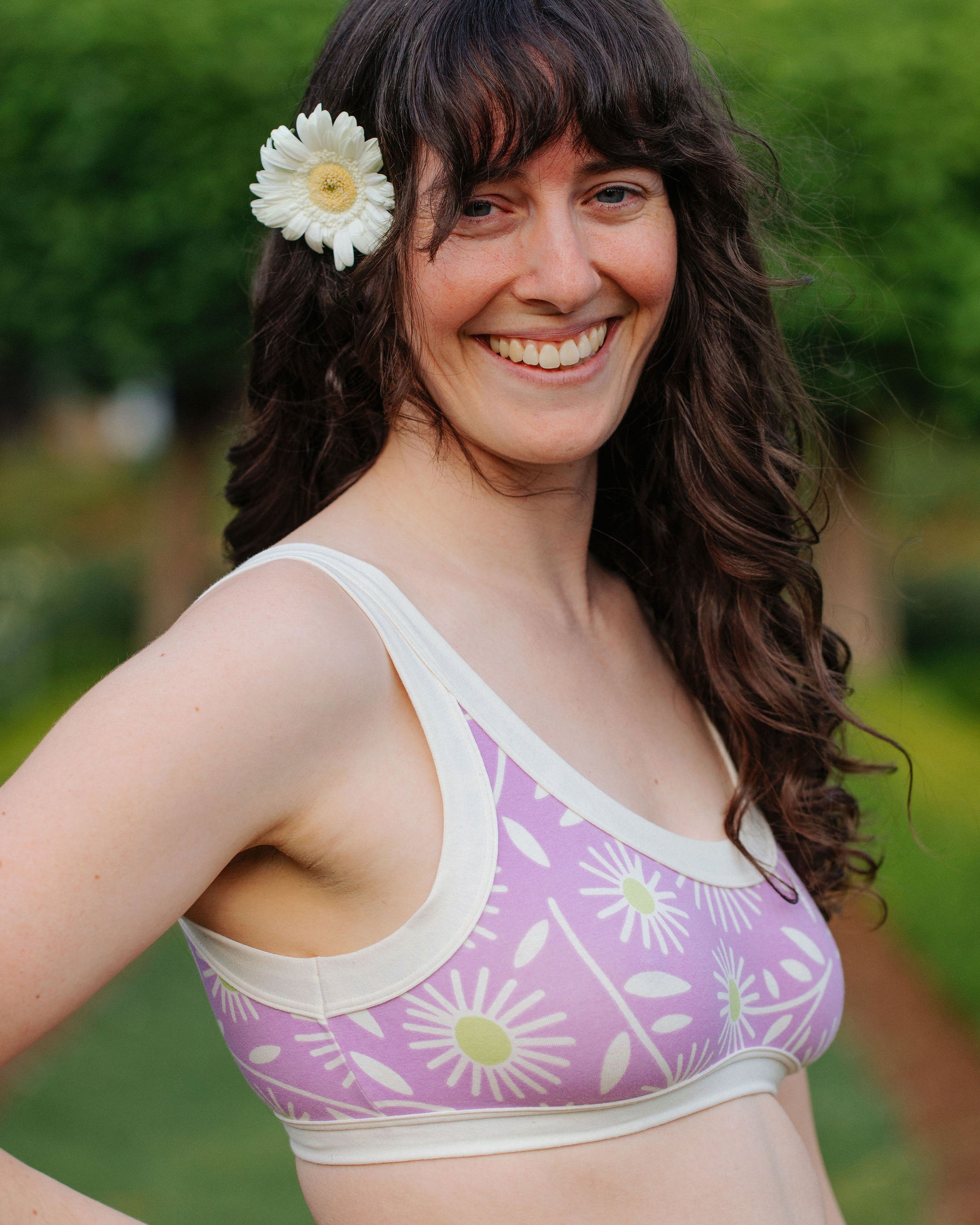 Model wearing Thunderpants Bralette in Delia's Daisy - white, green, and purple daisies print.