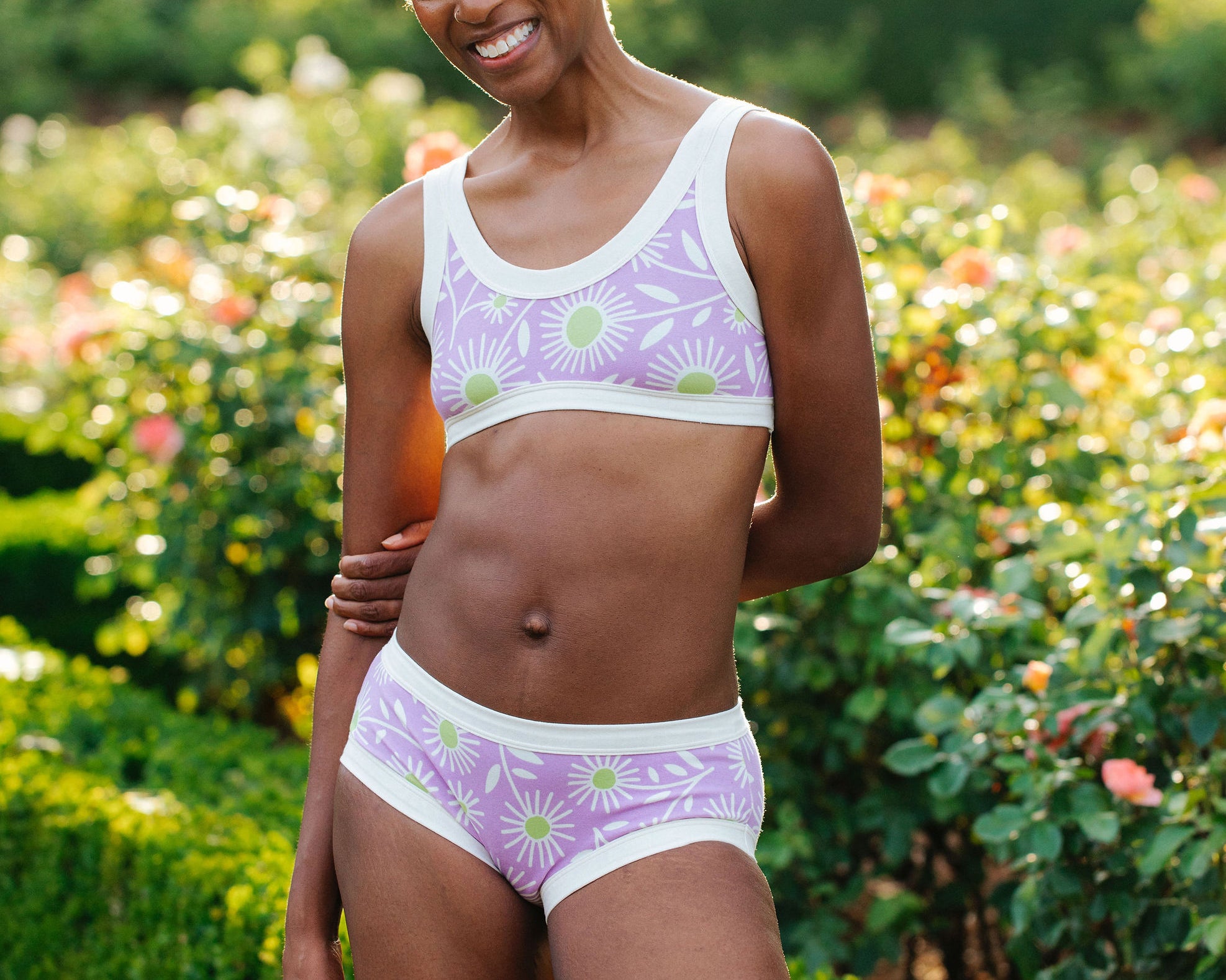 Model wearing Thunderpants Hipster style underwear and Bralette in Delia's Daisy - white, green, and purple daisies print.