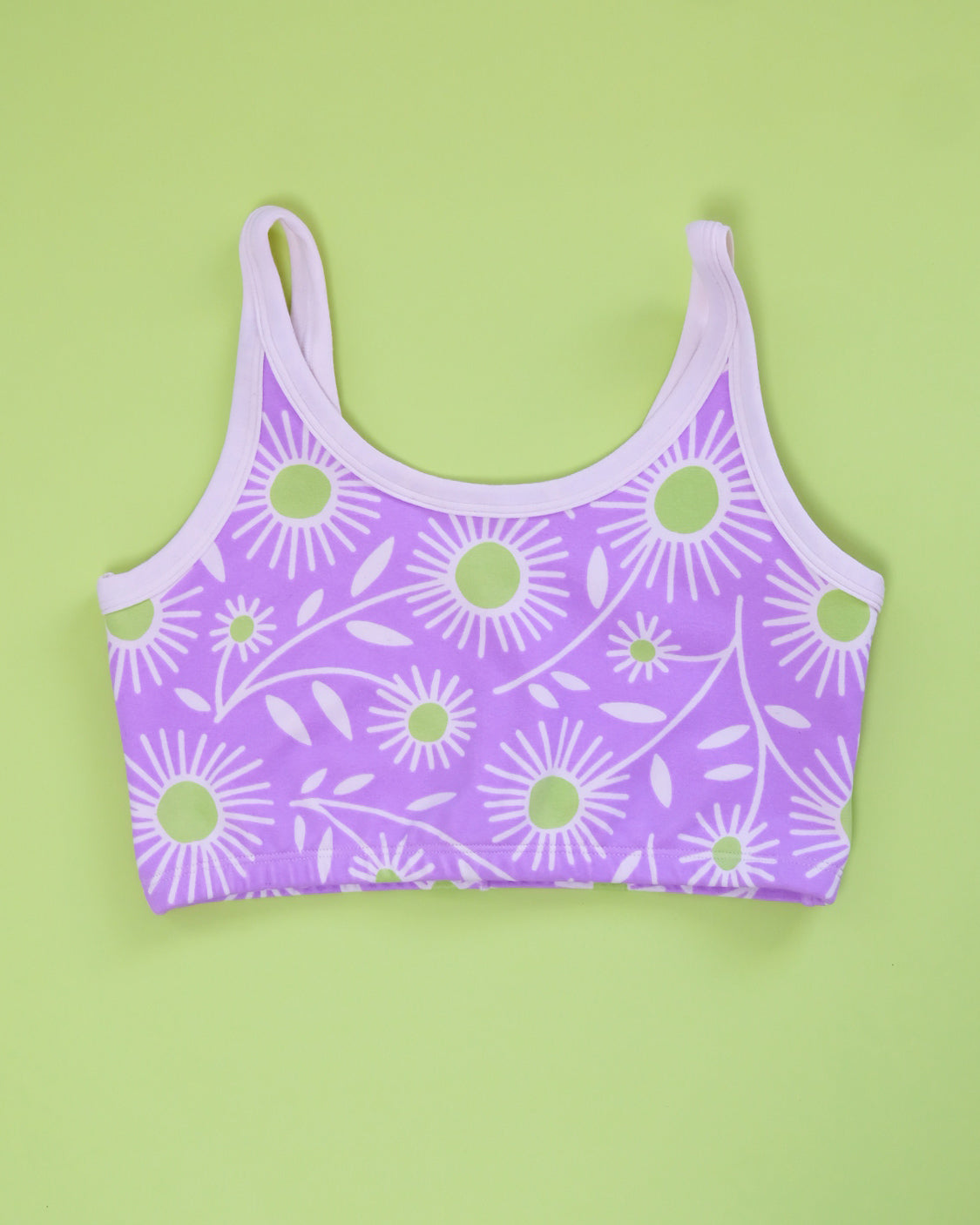Flat lay of Thunderpants Longline Bra in Delia's Daisy - white, green, and purple daisies print.