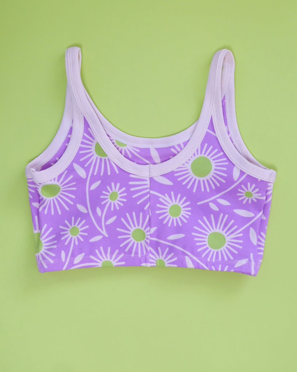 Flat lay of Thunderpants Longline Bra in Delia's Daisy - white, green, and purple daisies print.