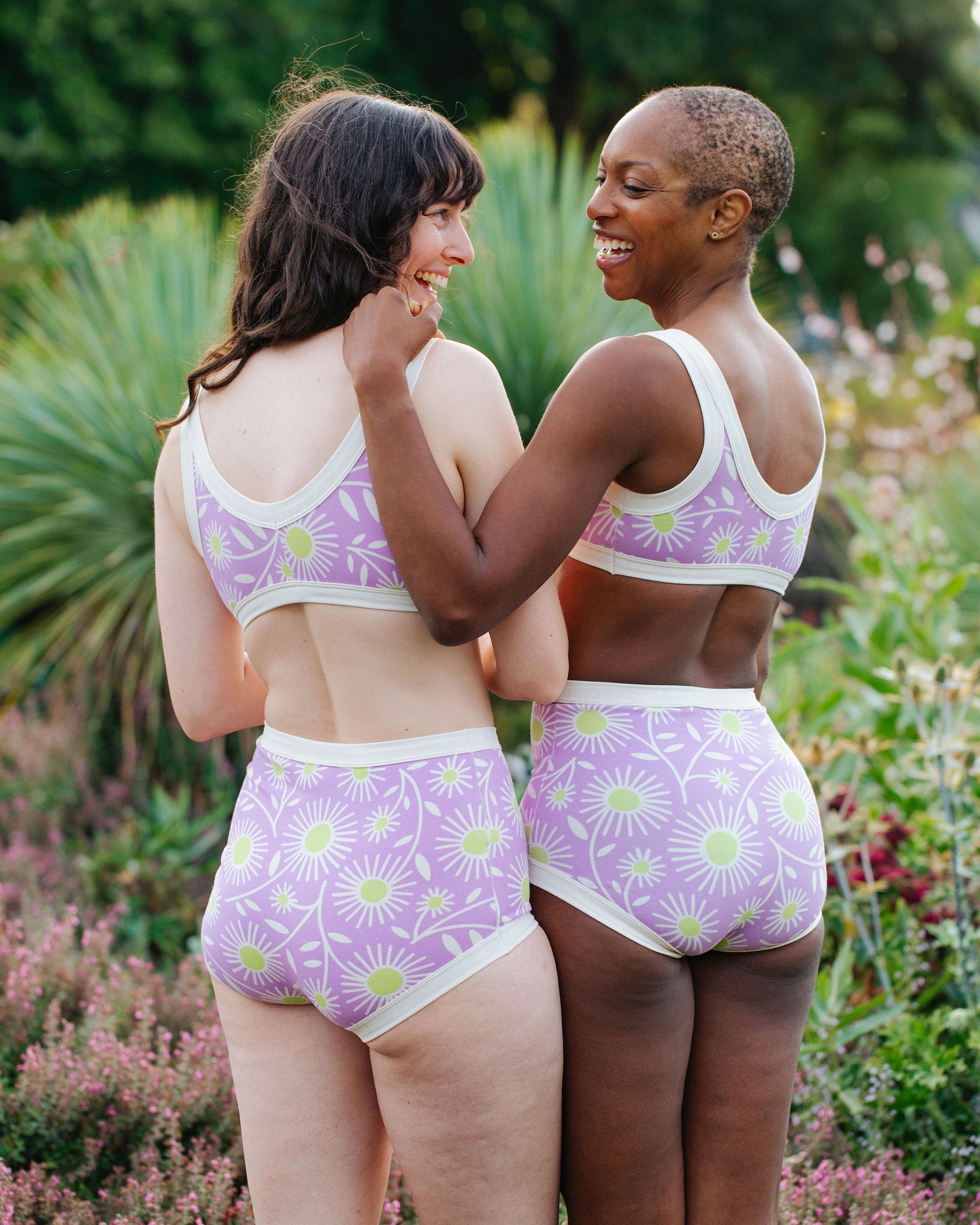 Models wearing Thunderpants Sky Rise style underwear and Bralettes in Delia's Daisy - white, green, and purple daisies print.