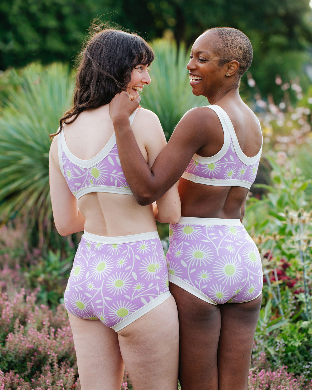 Models wearing Thunderpants Sky Rise style underwear and Bralettes in Delia's Daisy - white, green, and purple daisies print.