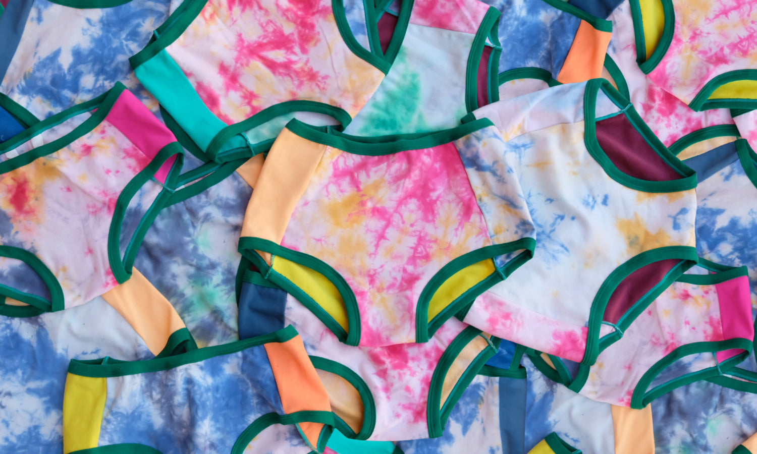 Tons of Thunderpants Hipster and Original style underwear laying on top of eachother in Dye Scrap Panel Pants - different solid colors with different dyed fabrics.