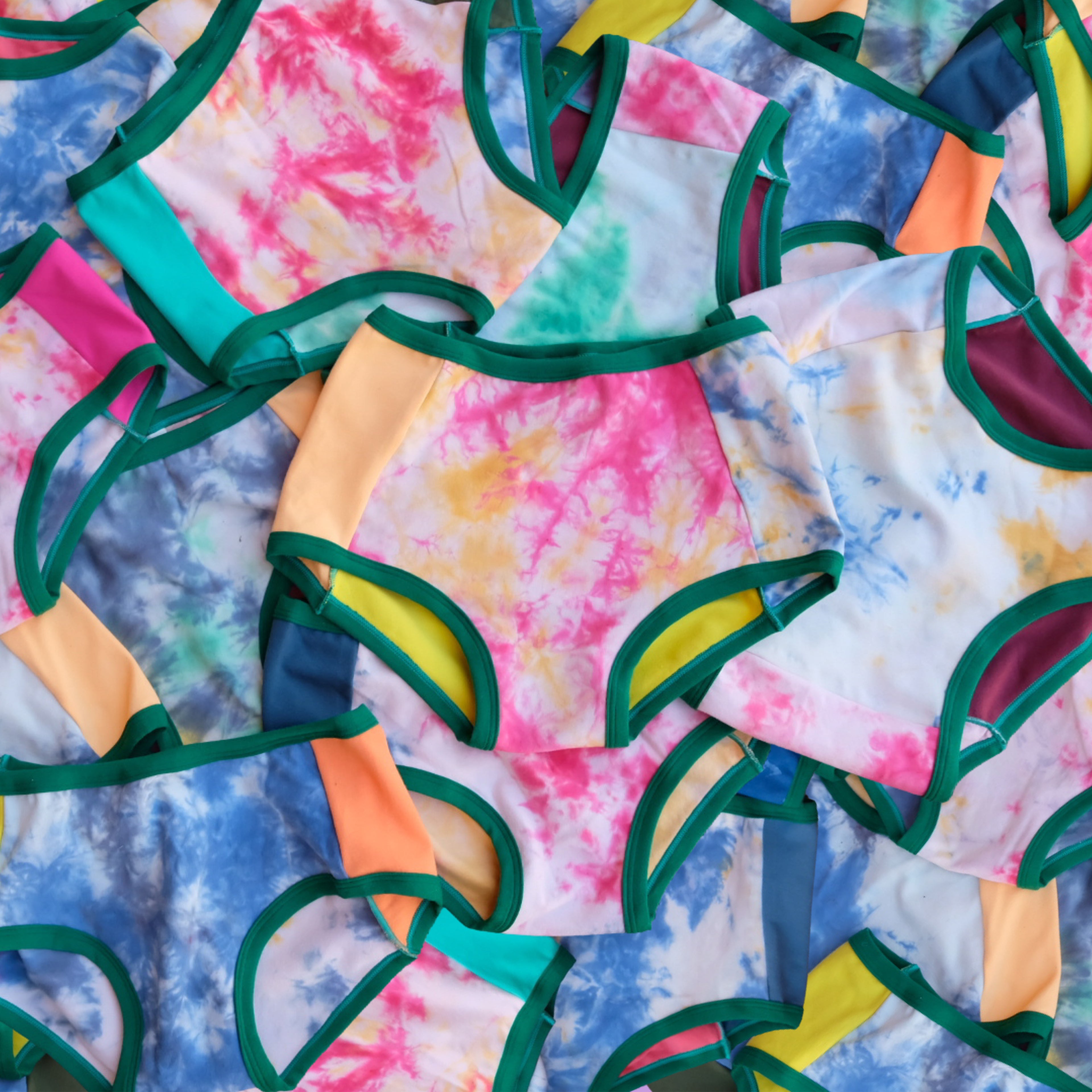 Tons of Thunderpants Hipster and Original style underwear laying on top of eachother in Dye Scrap Panel Pants - different solid colors with different dyed fabrics.
