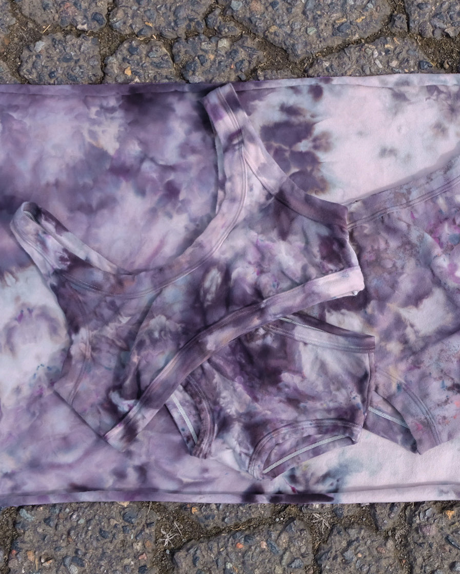 Flat Lay of Thunderpants Bralette in Haunted Haze Ice Dye - purply grey dye pattern.