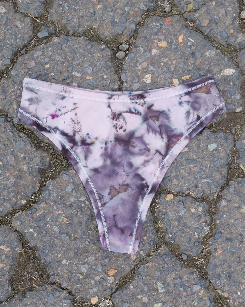 Flat lay of Thunderpants Thong style underwear in Haunted Haze Ice Dye - purply grey dye pattern.