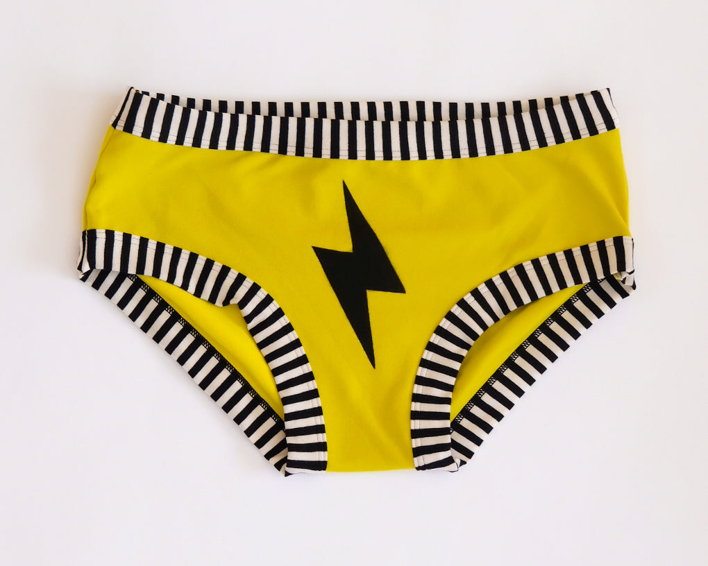 Flat lay of Thunderpants Hipster style underwear in Thunderstruck - yellow with a black lightning bolt.