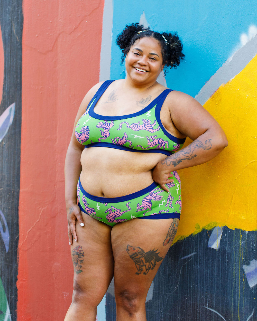 Model wearing Thunderpants organic cotton Hipster style underwear and Bralette in Electric Tiger - green with pink and blue tigers and white lightning bolts.