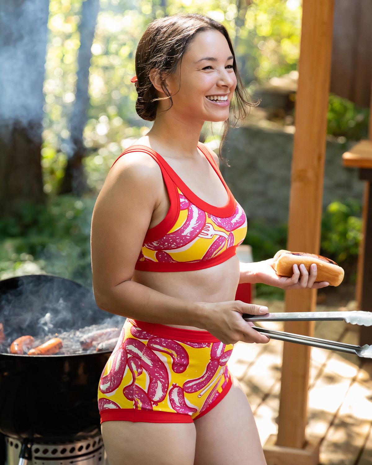 Model wearing Thunderpants Bralette and Sky Rise style underwear in Hot Dawg! print - pink sausages on yellow background and red binding.