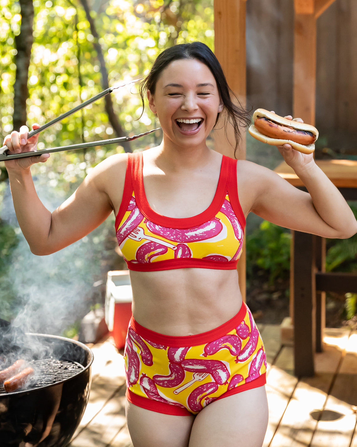 Model wearing Thunderpants Bralette and Sky Rise style underwear in Hot Dawg! print - pink sausages on yellow background and red binding.