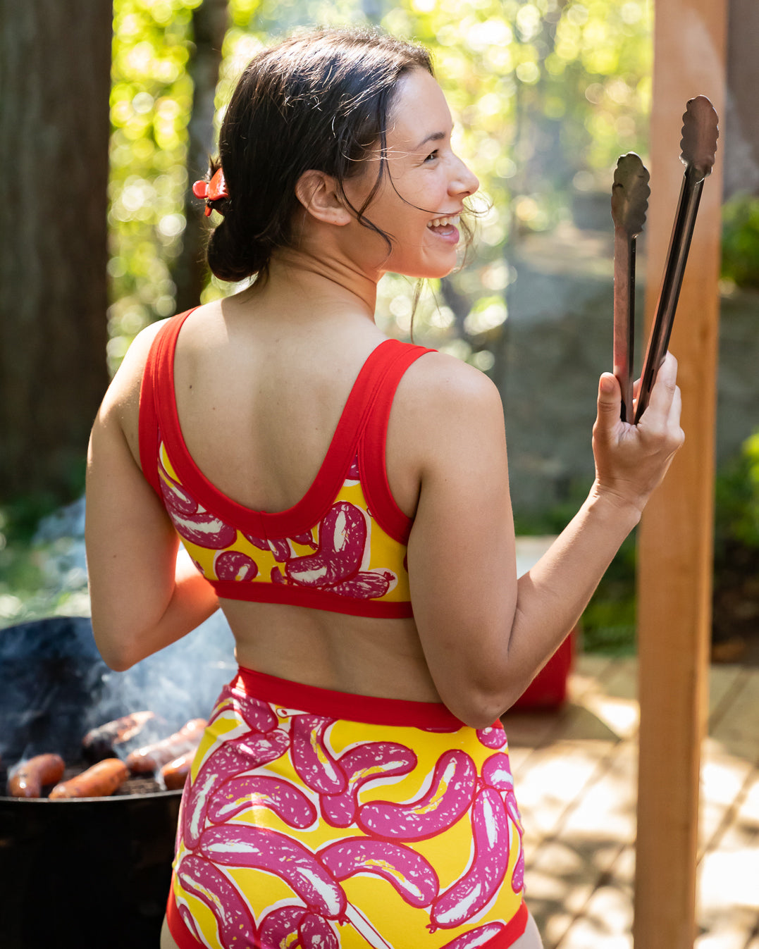 Model wearing Thunderpants Bralette and Sky Rise style underwear in Hot Dawg! print - pink sausages on yellow background and red binding.