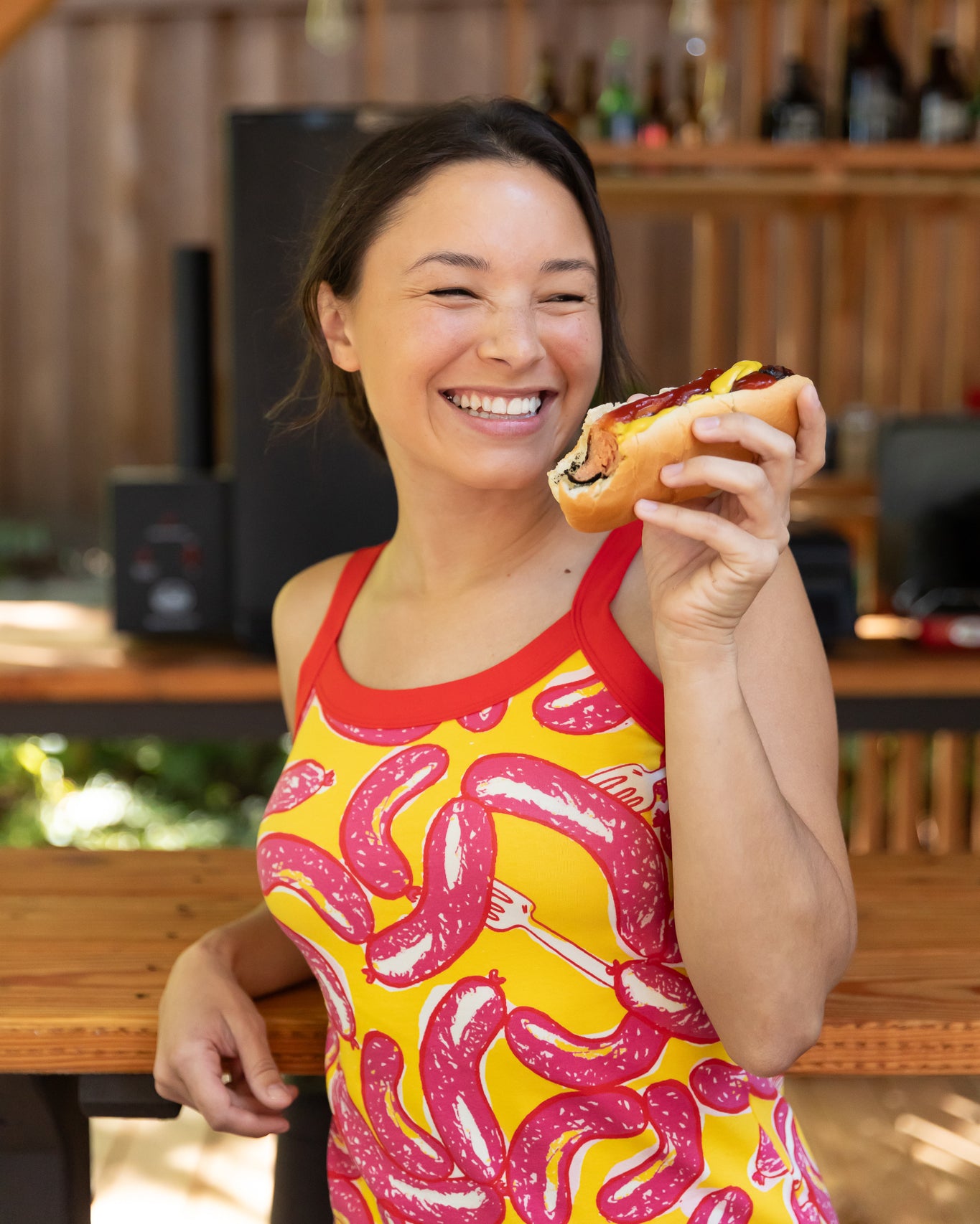 Modeling wearing Thunderpants Cami in Hot Dawg! print - pink sausages on yellow background and red binding.