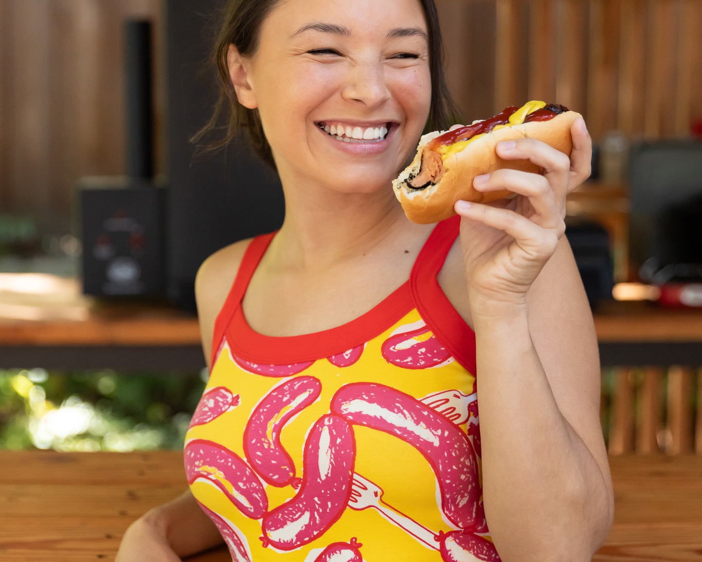 Modeling wearing Thunderpants Cami in Hot Dawg! print - pink sausages on yellow background and red binding.