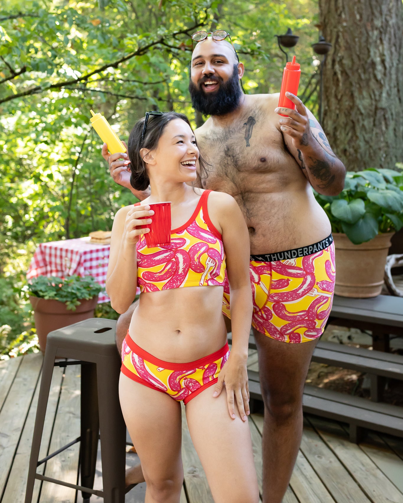Models wearing Thunderpants Hipster style underwear and Longline Bra in Hot Dawg! print - pink sausages on yellow background and red binding.