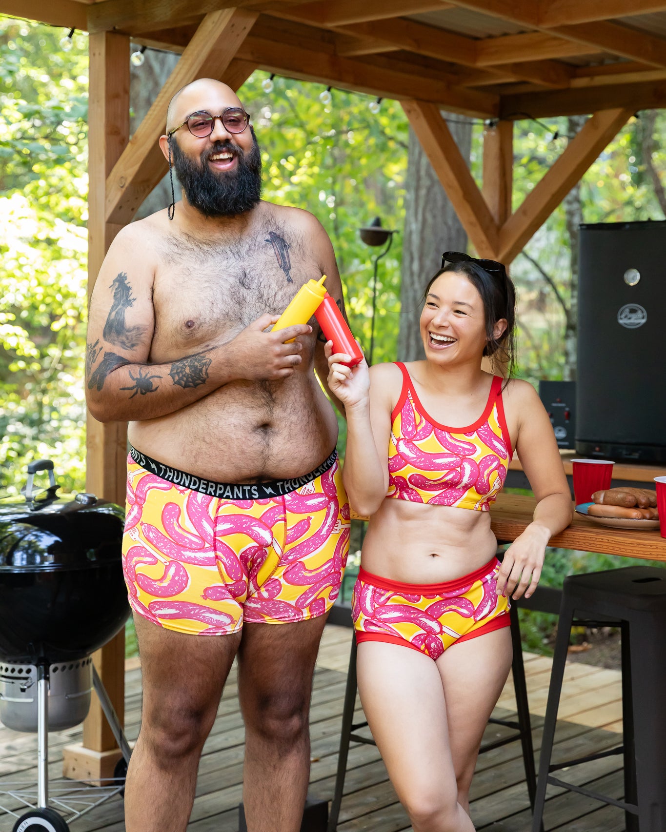 Model wearing Thunderpants Original style underwear and Longline Bra in Hot Dawg! print - pink sausages on yellow background and red binding.